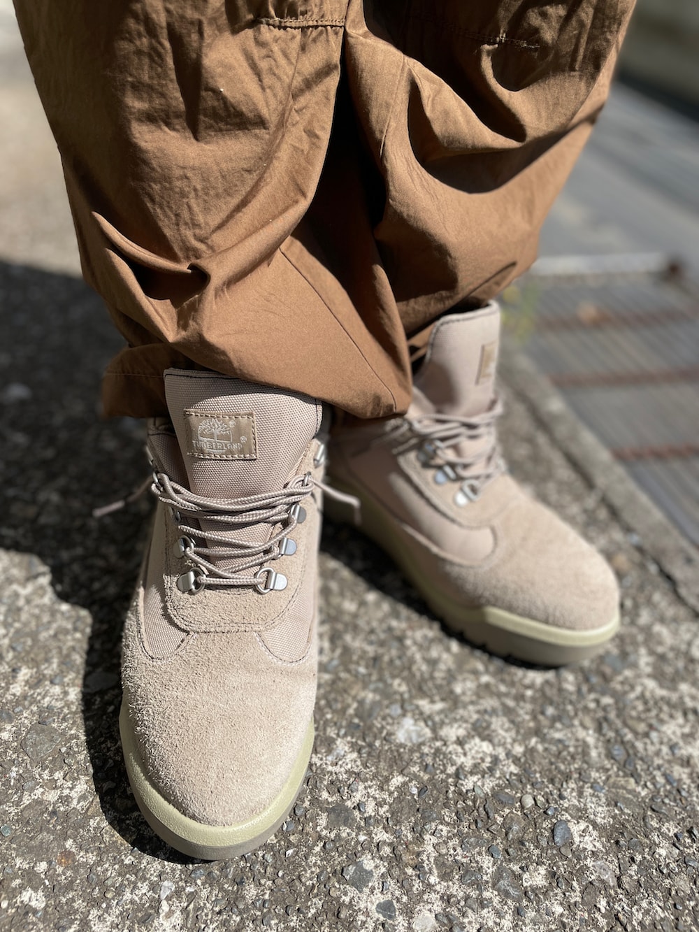 ベージュ系のブーツ、ブラウン系のカーゴパンツ、ブラック系のTシャツ/カットソーを着用したメンズの春コーディネートの3枚目の写真