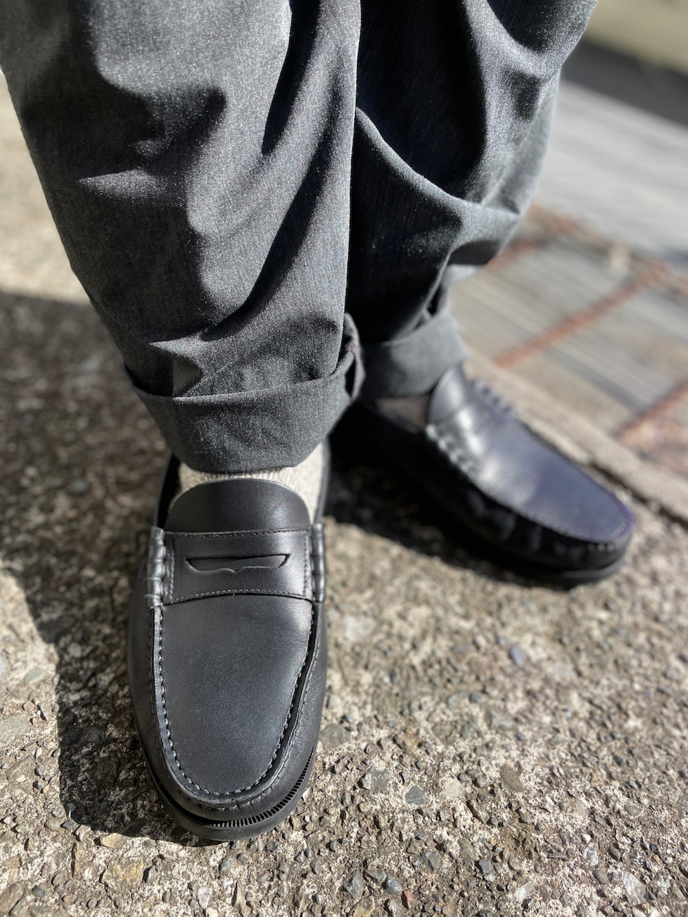 ブルー系のニット/セーター、グレー系のその他パンツ、ブラック系のローファーを着用したメンズの春コーディネートの3枚目の写真