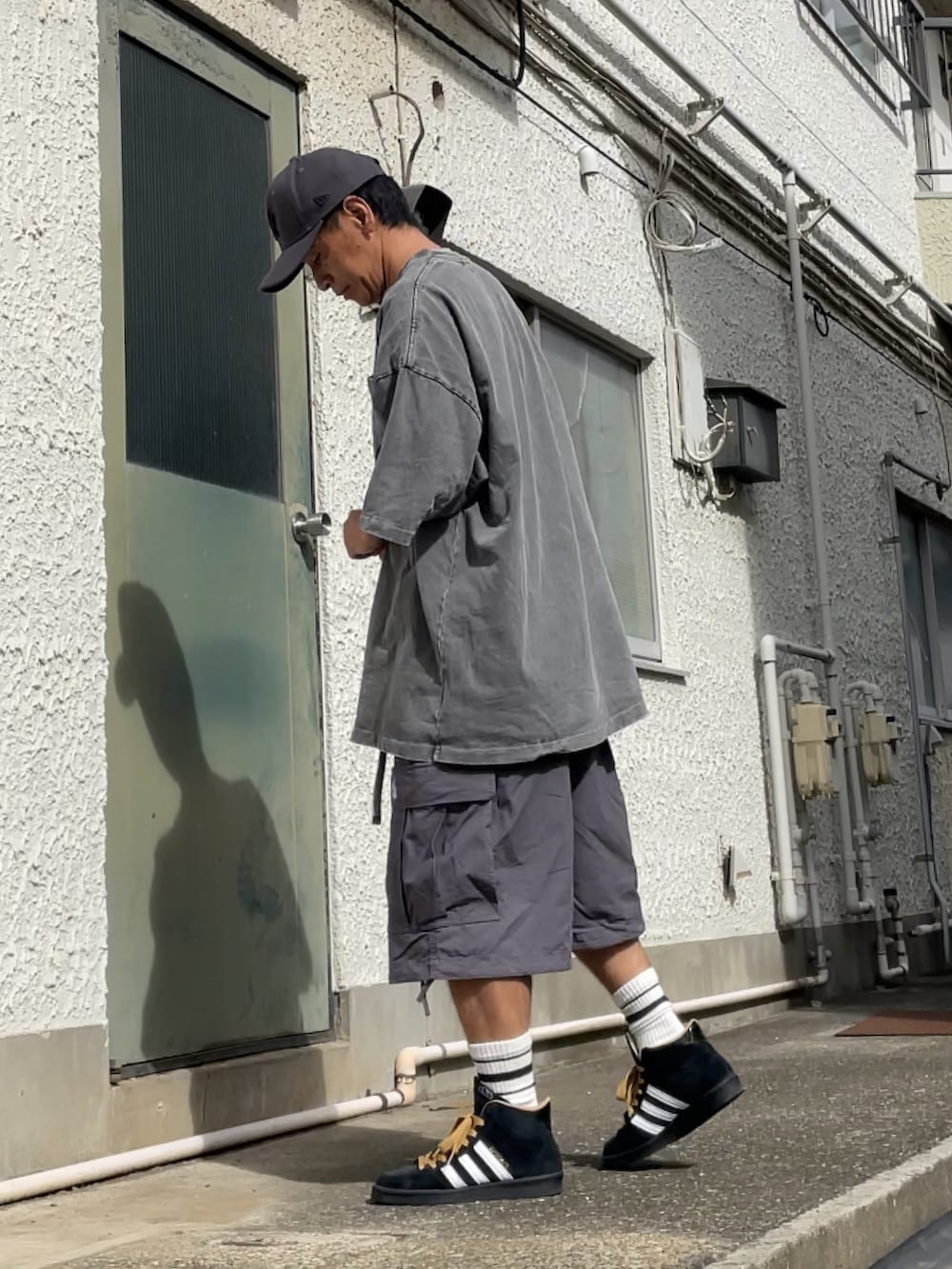 ブラック系のスニーカー、グレー系のカーゴパンツ、グレー系のTシャツ/カットソーを着用したメンズの秋コーディネートの2枚目の写真
