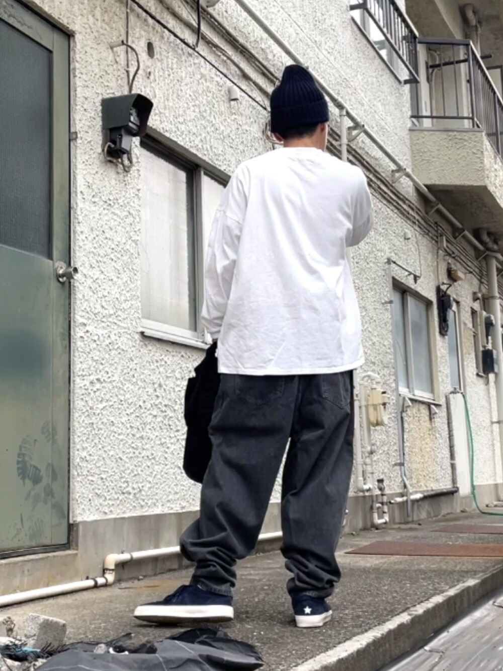 ブルー系のスニーカー、ブラック系のデニムパンツ、ホワイト系のTシャツ/カットソーを着用したメンズの秋コーディネートの2枚目の写真