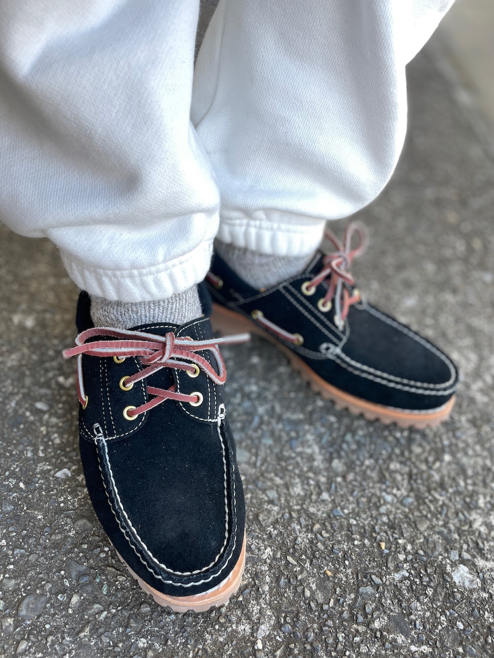 ブラック系のモカシン/デッキシューズ、ホワイト系のその他パンツ、ブラック系のTシャツ/カットソーを着用したメンズの冬コーディネートの3枚目の写真