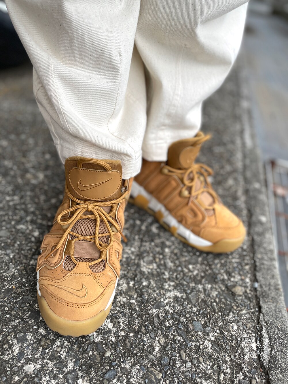 ブラウン系のスニーカー、ホワイト系のデニムパンツ、ブルー系のブルゾンを着用したメンズの冬コーディネートの3枚目の写真