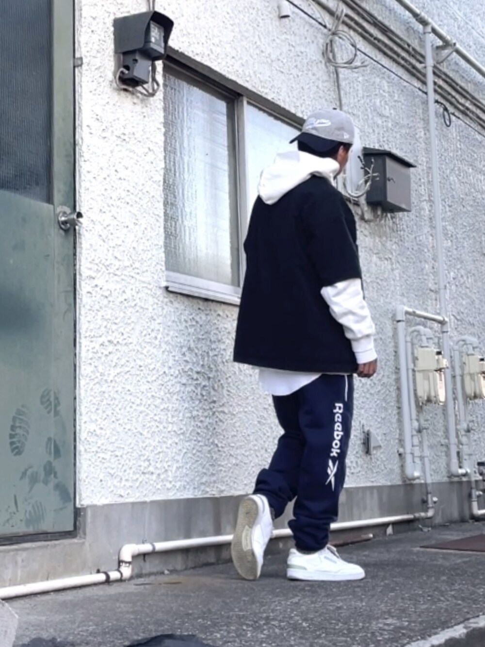 ホワイト系のスニーカー、ブルー系のスウェットパンツ、ブラック系のTシャツ/カットソーを着用したメンズの冬コーディネートの3枚目の写真