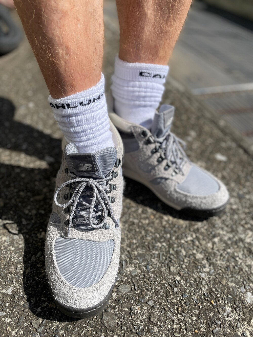 グレー系のブーツ、ブルー系のその他パンツ、ブラック系のTシャツ/カットソーを着用したメンズの夏コーディネートの3枚目の写真