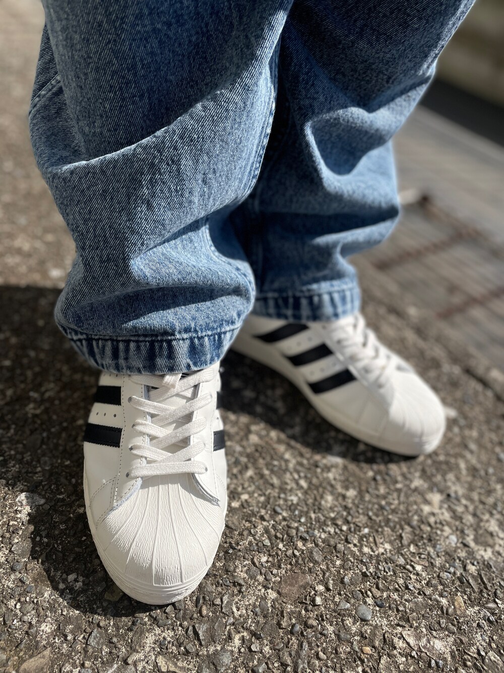 ホワイト系のスニーカー、ブルー系のデニムパンツ、ホワイト系のTシャツ/カットソーを着用したメンズの春コーディネートの3枚目の写真