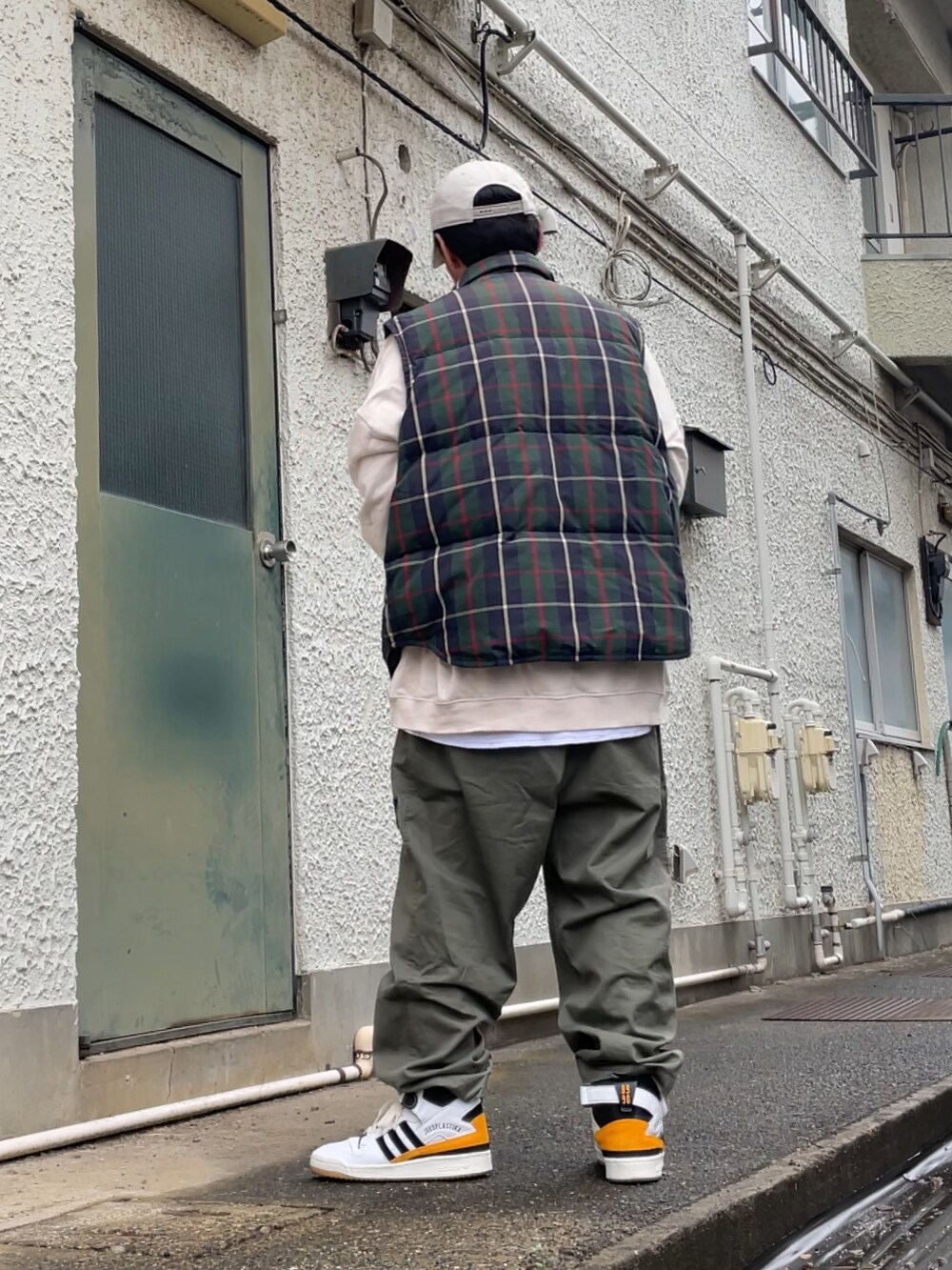 ホワイト系のスニーカー、グリーン系のその他パンツ、グリーン系のダウンベストを着用したメンズの春コーディネートの2枚目の写真