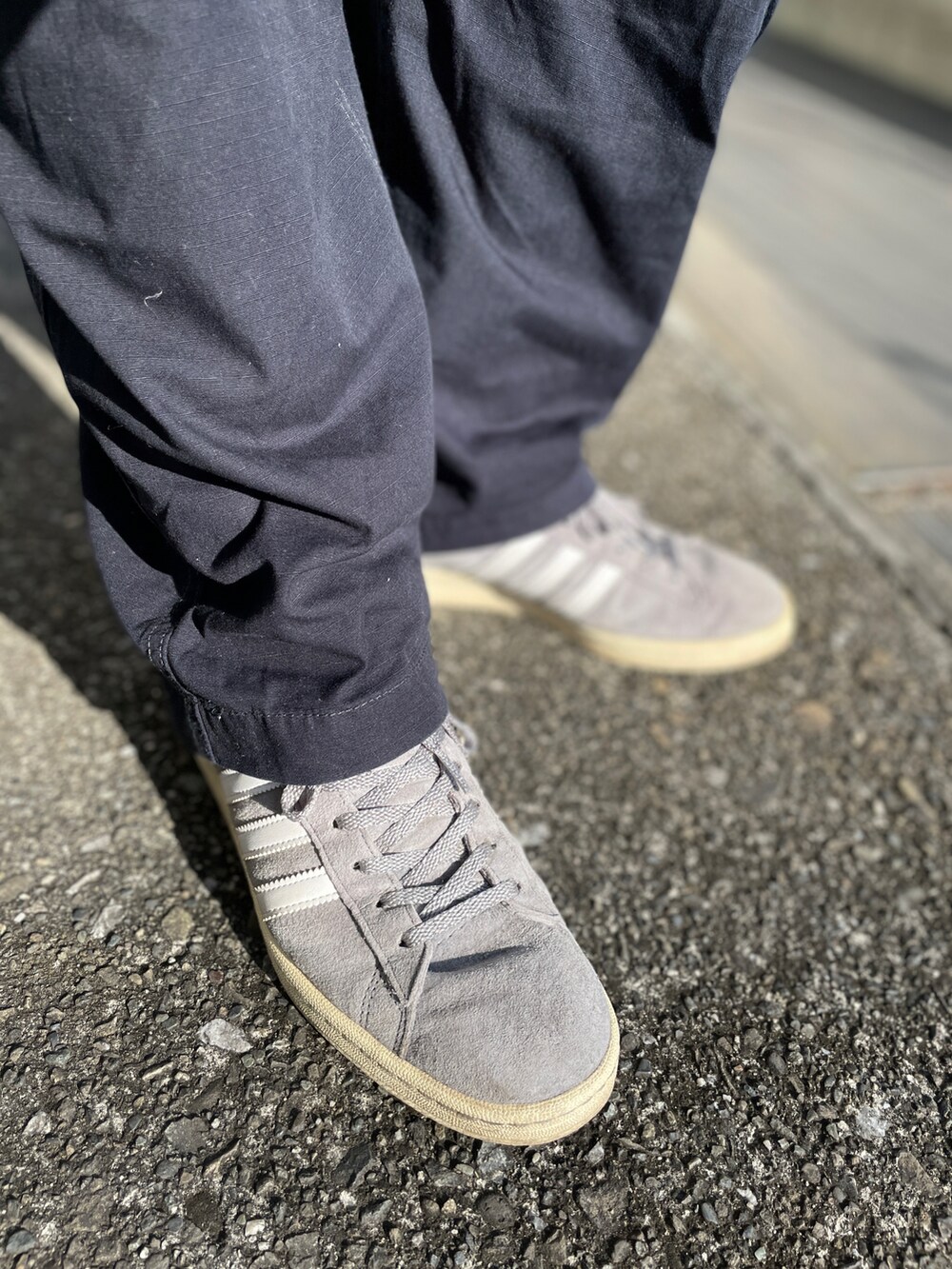 グレー系のスニーカー、ブルー系のカーゴパンツ、ブラウン系のパーカーを着用したメンズの秋コーディネートの3枚目の写真