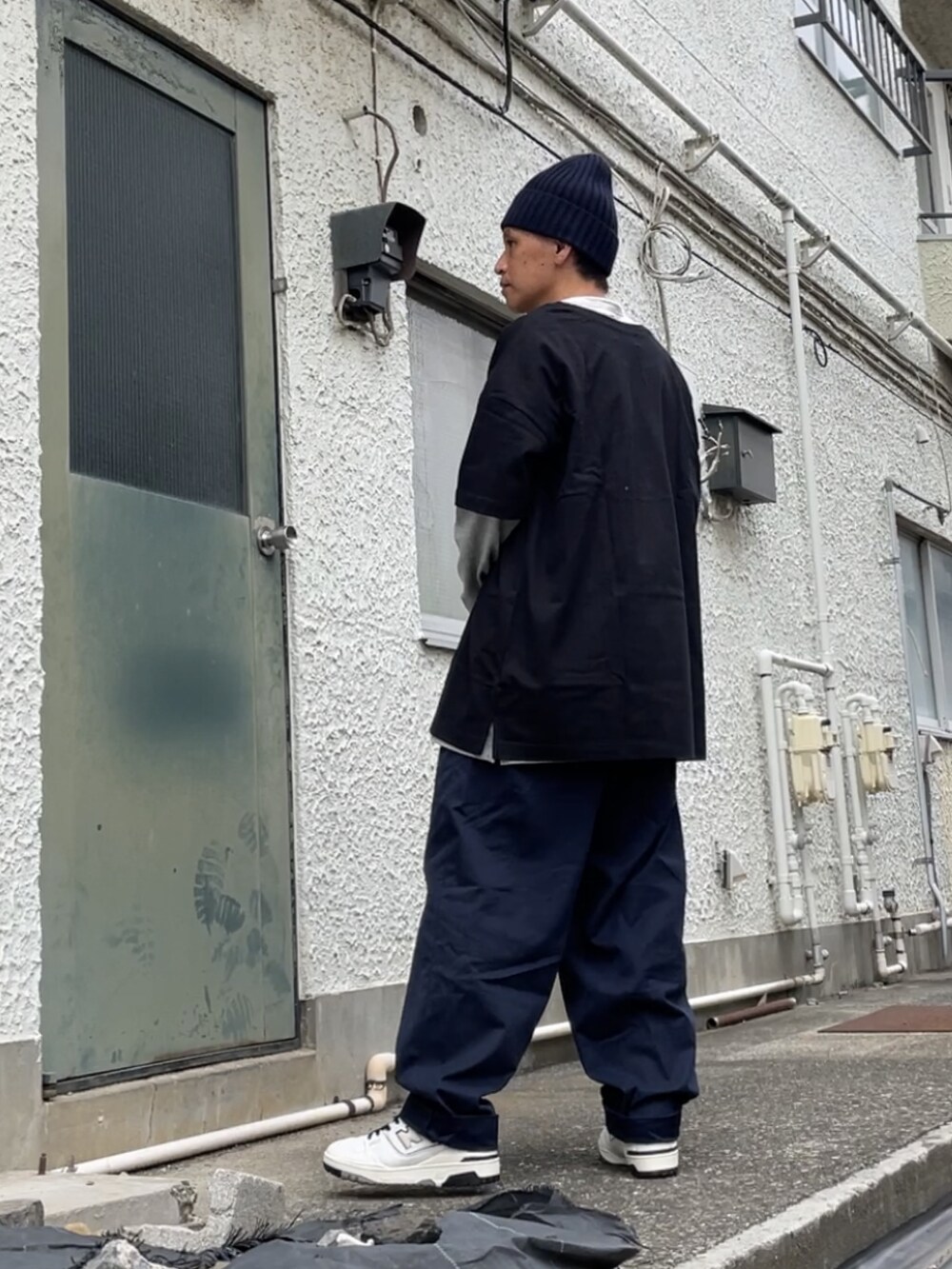 ホワイト系のスニーカー、ブルー系のチノパンツ、ブラック系のTシャツ/カットソーを着用したメンズの秋コーディネートの2枚目の写真