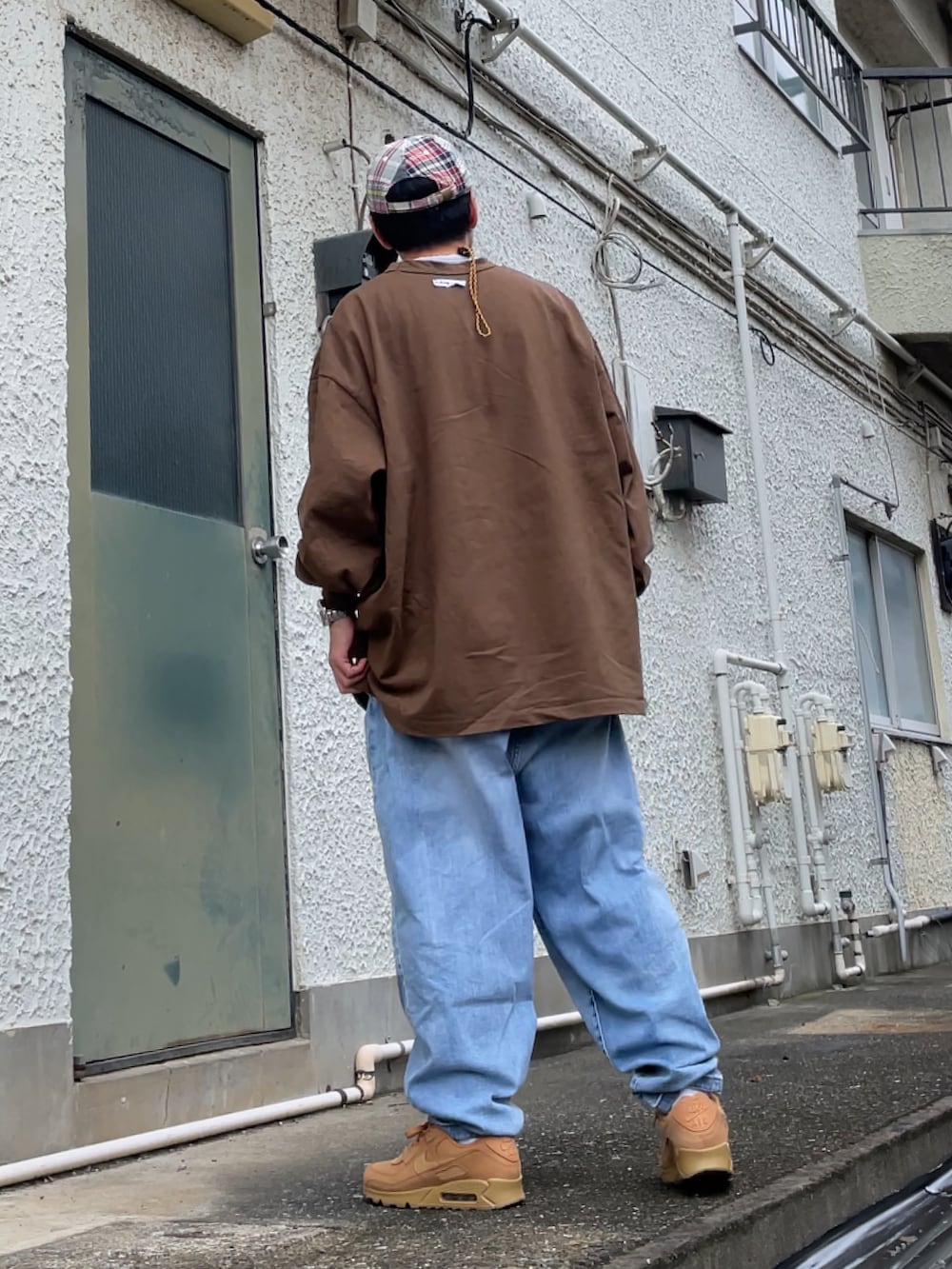ブラウン系のスニーカー、ブルー系のデニムパンツ、ブラウン系のTシャツ/カットソーを着用したメンズの秋コーディネートの2枚目の写真