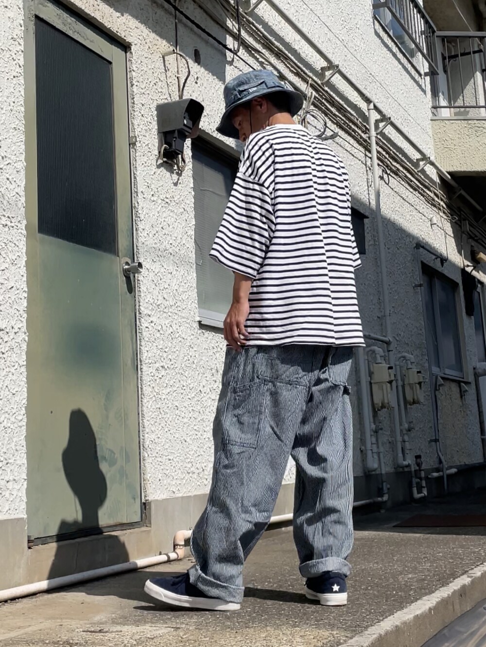 ブルー系のスニーカー、その他のデニムパンツ、ホワイト系のTシャツ/カットソーを着用したメンズの夏コーディネートの2枚目の写真