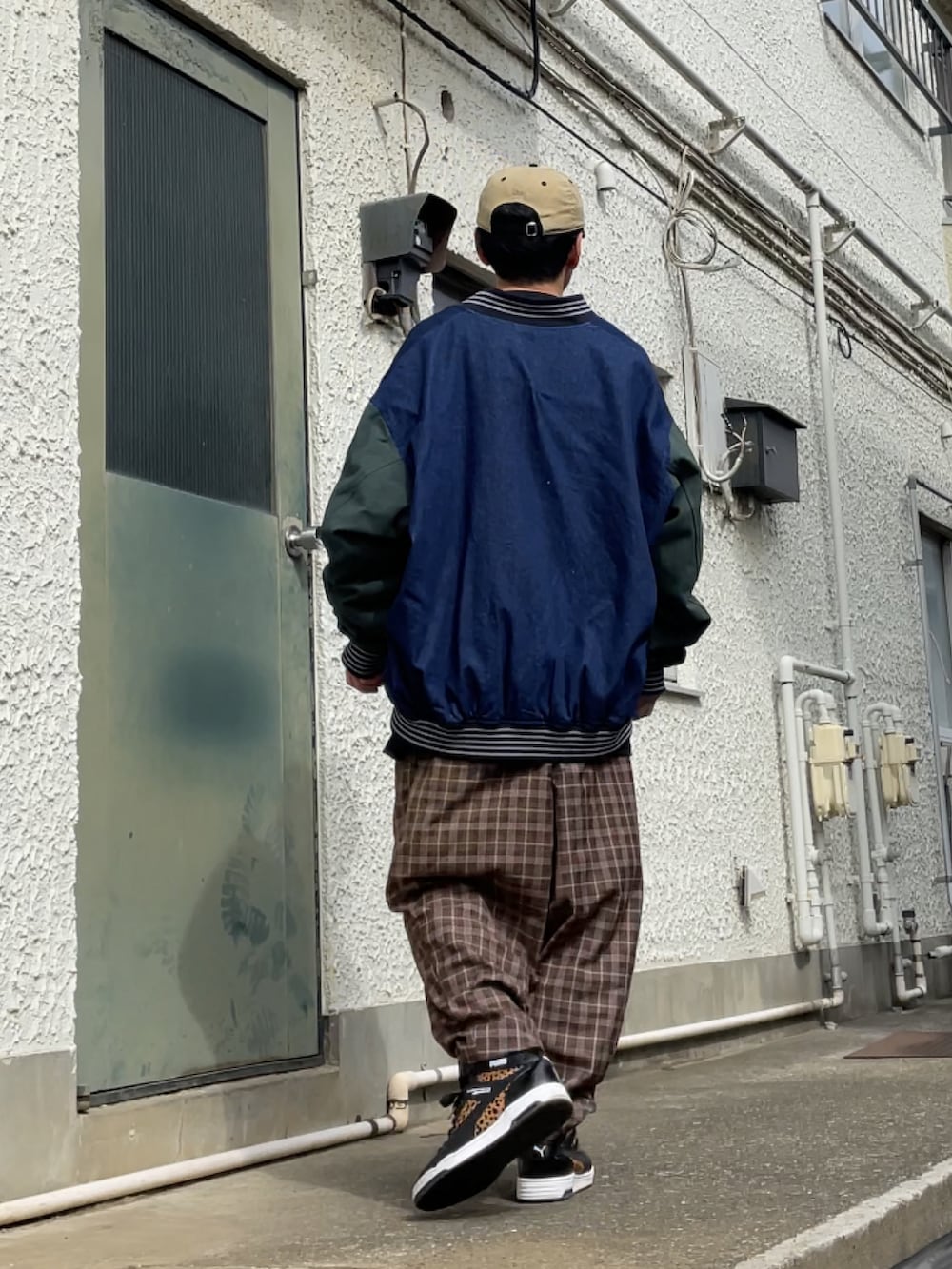 ブラック系のスニーカー、ブラウン系のその他パンツ、ブルー系のスタジャンを着用したメンズの春コーディネートの2枚目の写真