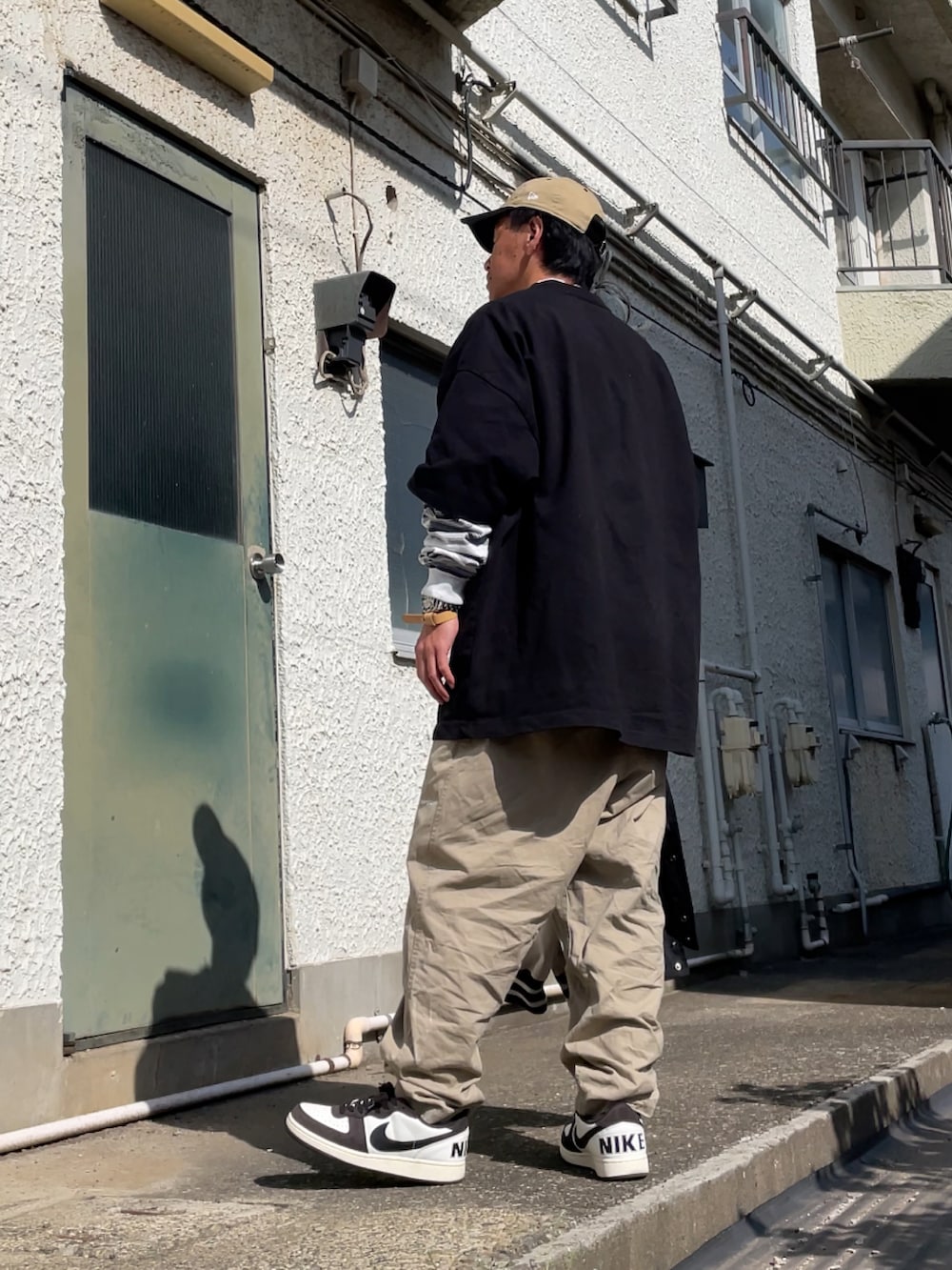 ブラウン系のスニーカー、ベージュ系のチノパンツ、グレー系のTシャツ/カットソーを着用したメンズの春コーディネートの2枚目の写真