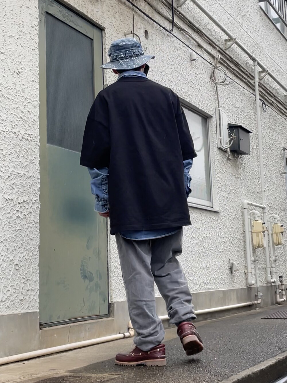 レッド系のモカシン/デッキシューズ、グレー系のスウェットパンツ、ブラック系のTシャツ/カットソーを着用したメンズの春コーディネートの2枚目の写真