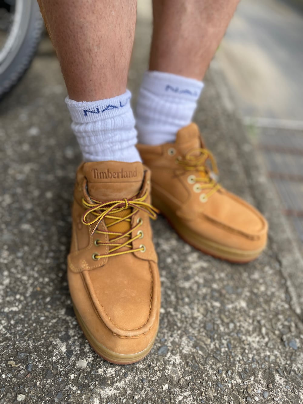 イエロー系のブーツ、ブルー系のその他パンツ、ホワイト系のTシャツ/カットソーを着用したメンズの夏コーディネートの3枚目の写真