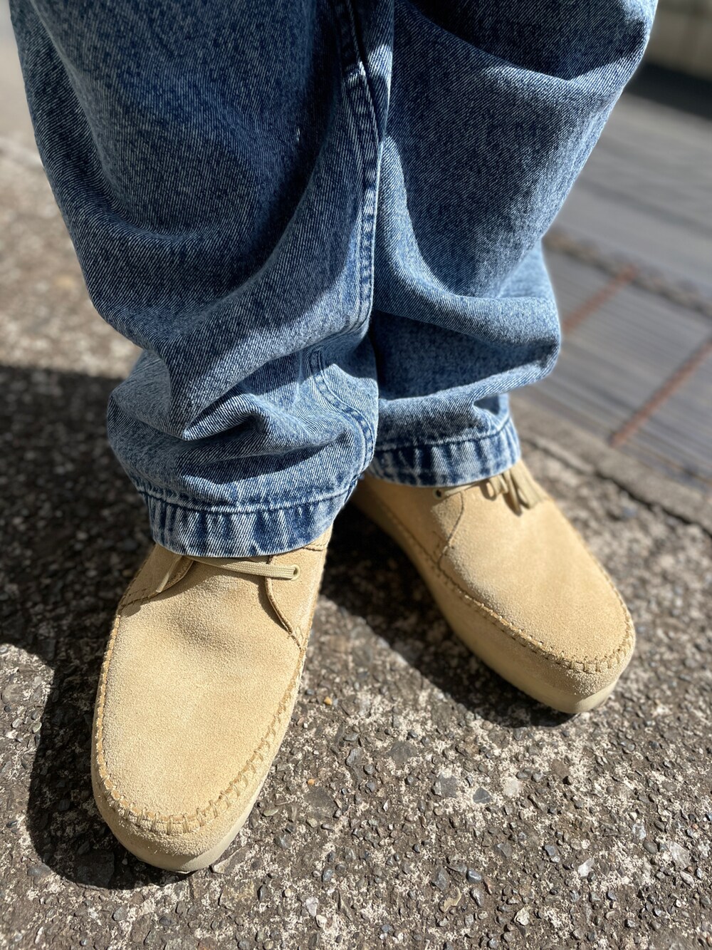 ベージュ系のモカシン/デッキシューズ、ブルー系のデニムパンツ、ブルー系のTシャツ/カットソーを着用したメンズの春コーディネートの3枚目の写真