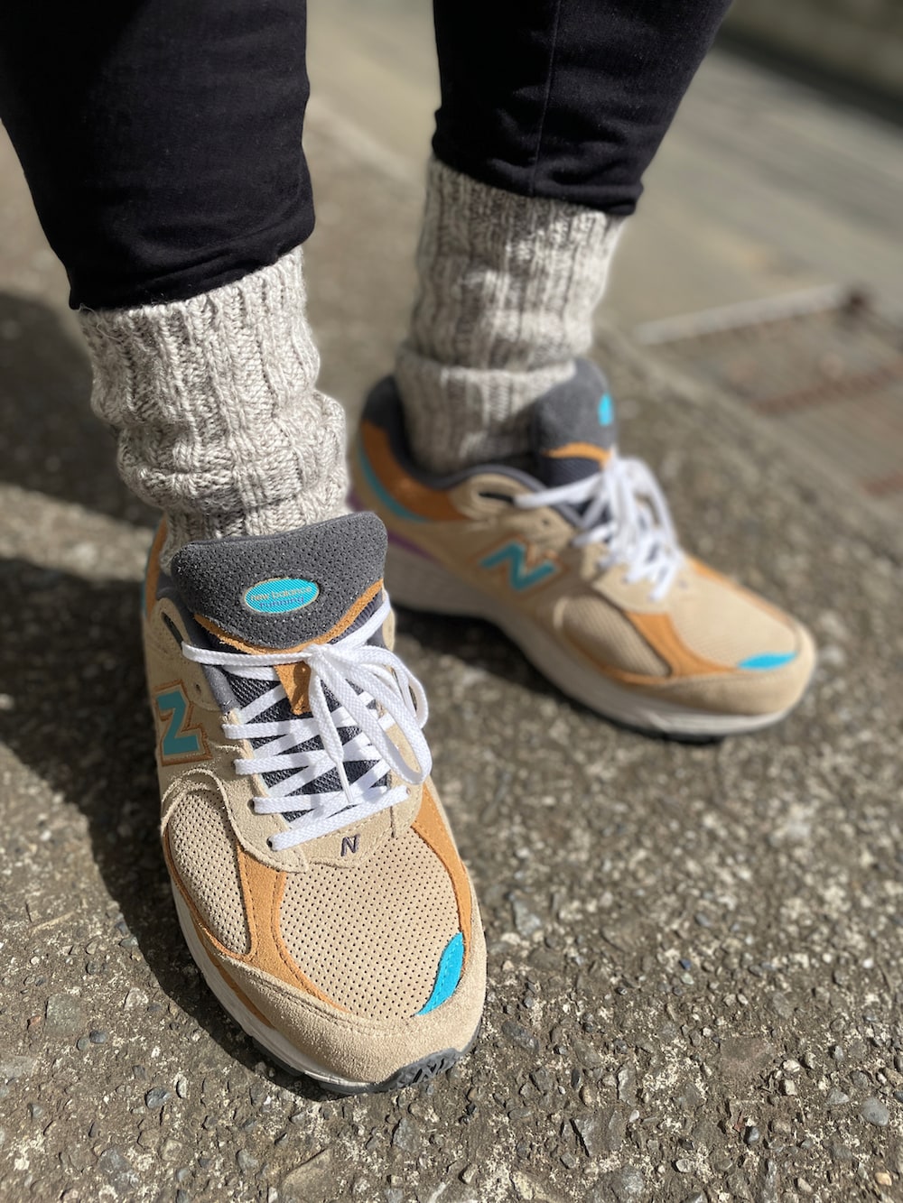 ベージュ系のスニーカー、ブルー系のその他パンツ、ブラウン系のTシャツ/カットソーを着用したメンズの春コーディネートの3枚目の写真