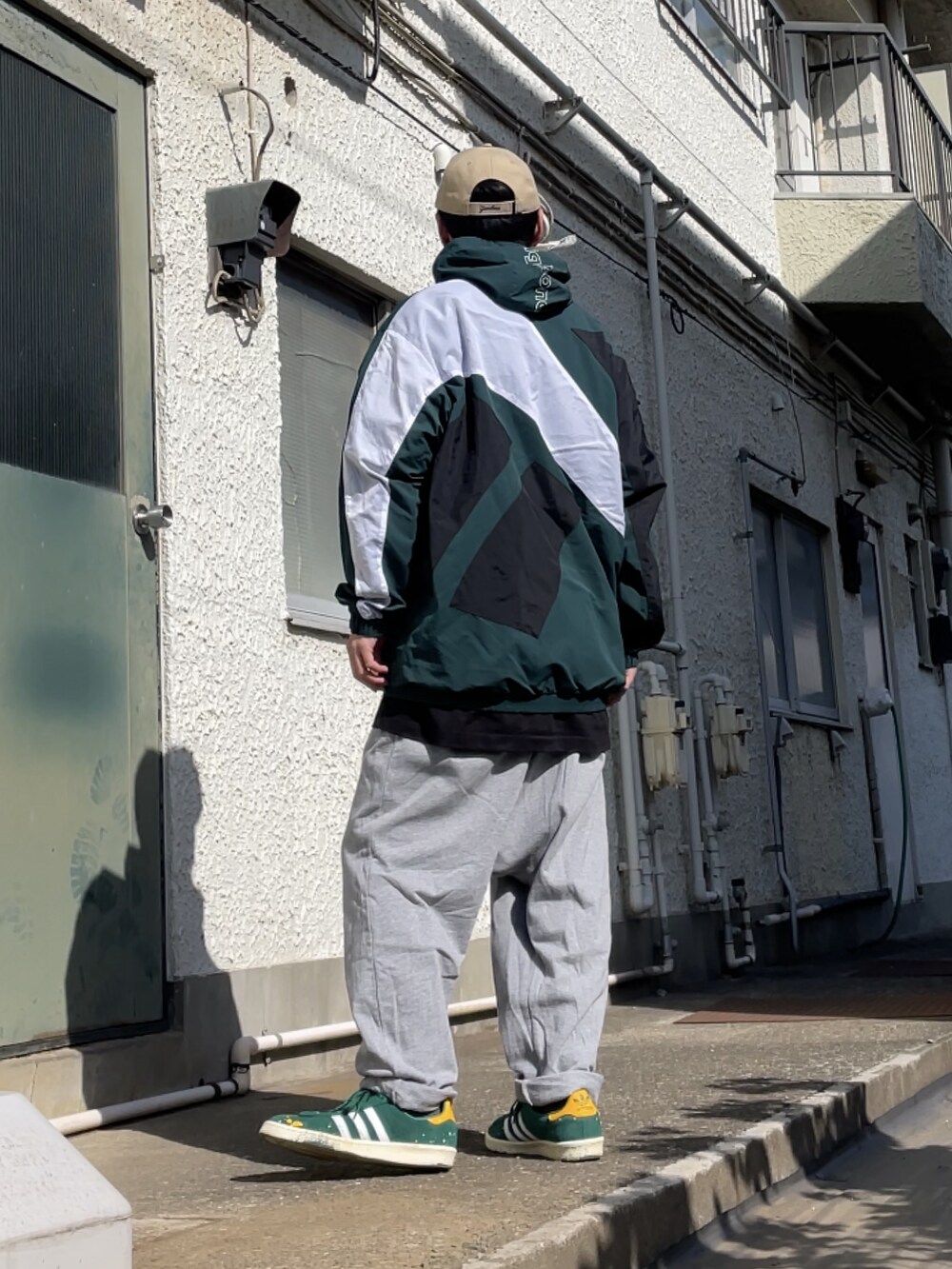 グリーン系のスニーカー、グレー系のその他パンツ、グリーン系のマウンテンパーカーを着用したメンズの春コーディネートの2枚目の写真