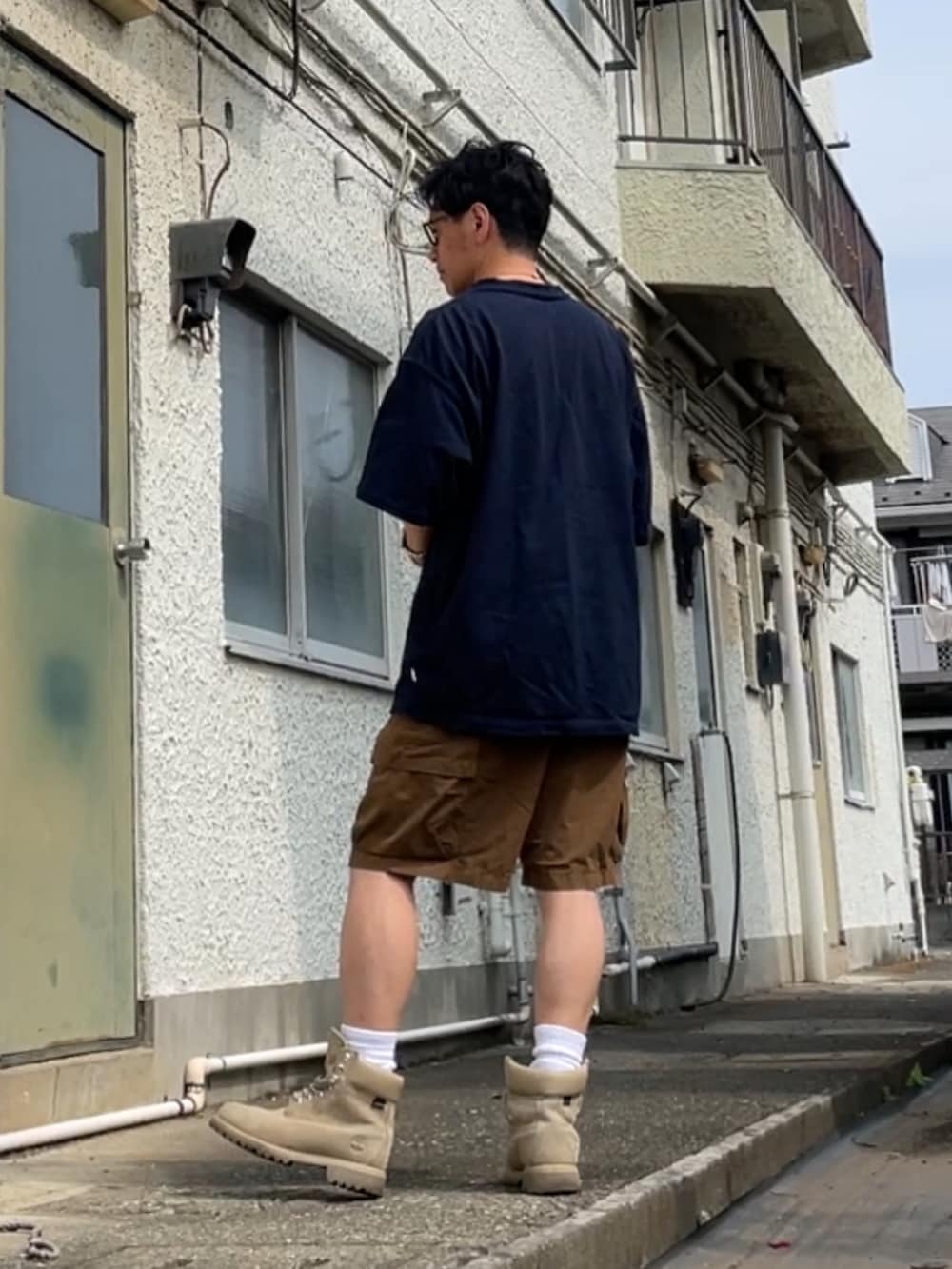 ブルー系のTシャツ/カットソー、ブラウン系のカーゴパンツ、ベージュ系のブーツを着用したメンズの夏コーディネートの2枚目の写真