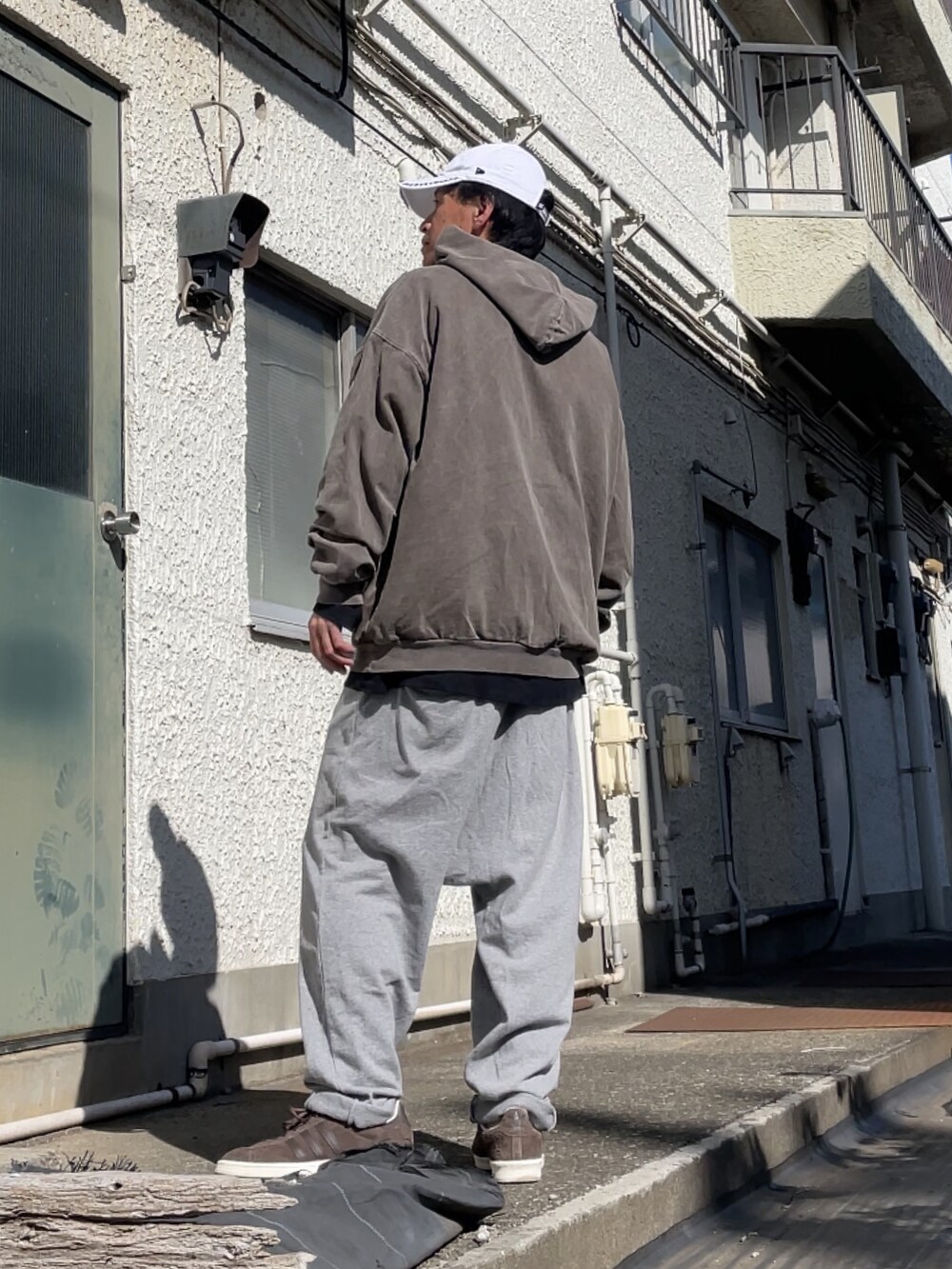 ブラウン系のスニーカー、グレー系のその他パンツ、ブラウン系のパーカーを着用したメンズの春コーディネートの2枚目の写真