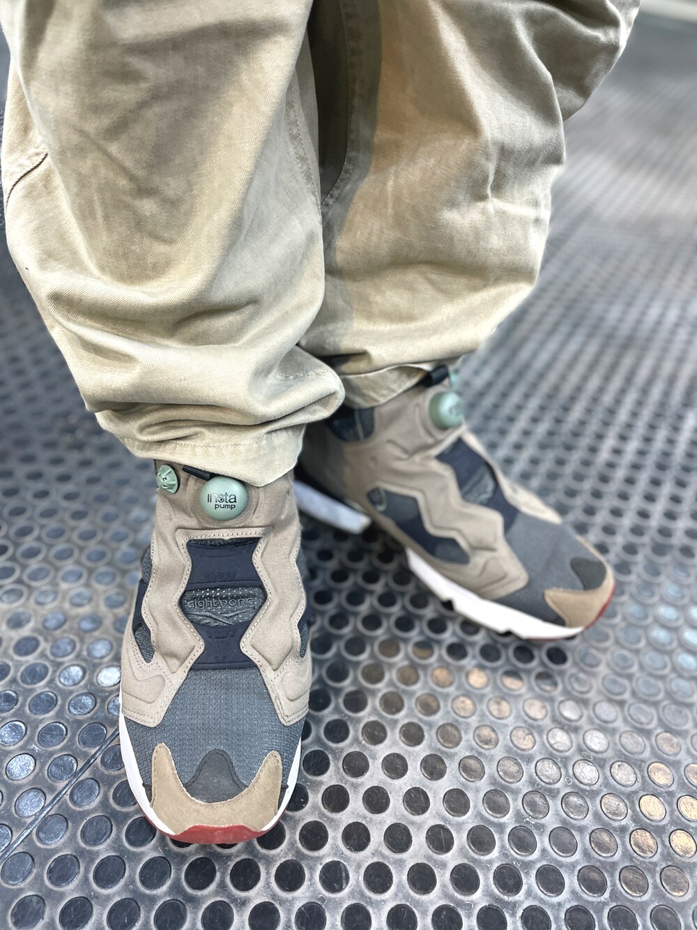 グレー系のスニーカー、ベージュ系のチノパンツ、グレー系のブルゾンを着用したメンズの冬コーディネートの3枚目の写真