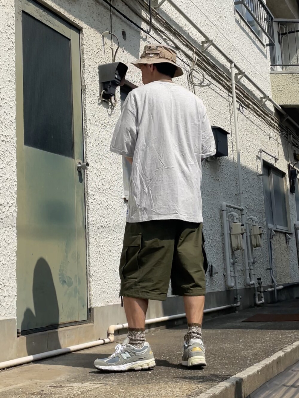 グレー系のスニーカー、グリーン系のカーゴパンツ、グレー系のTシャツ/カットソーを着用したメンズの夏コーディネートの2枚目の写真
