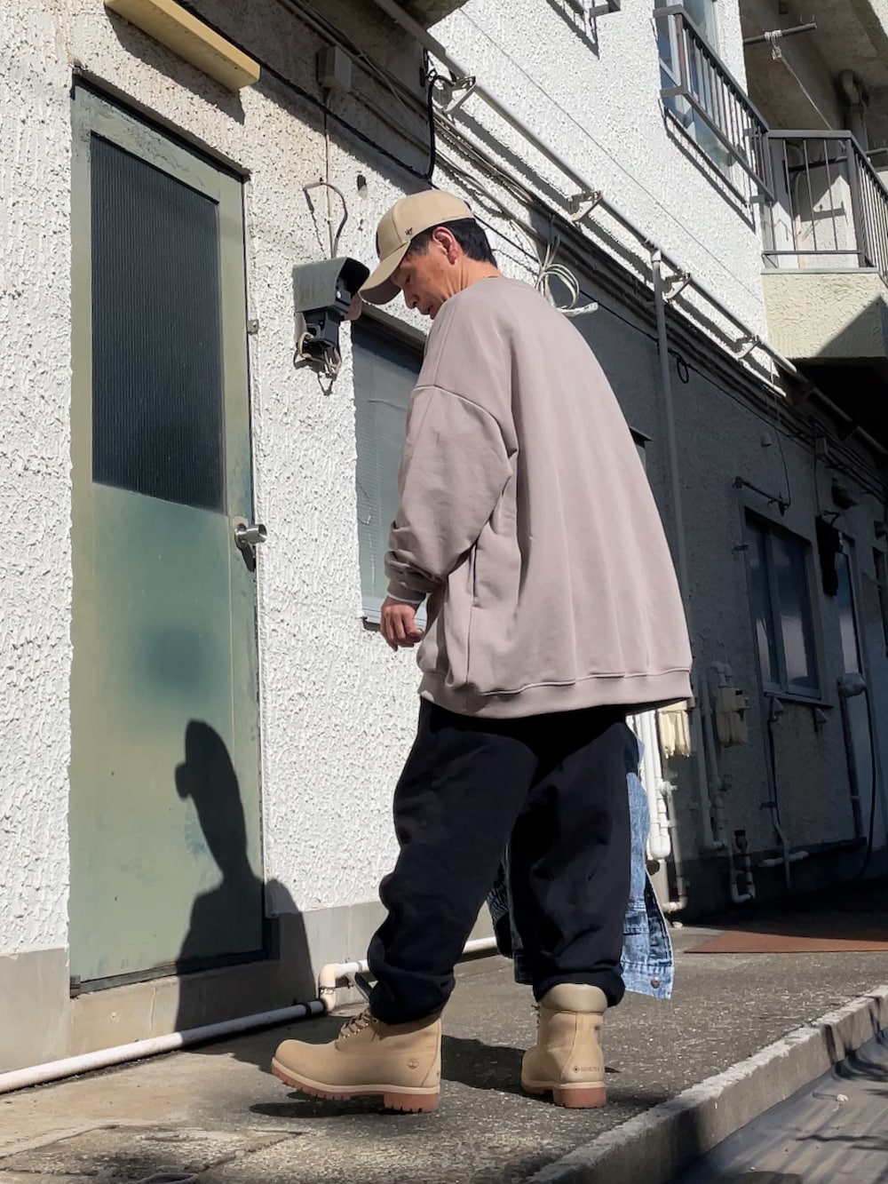 ベージュ系のブーツ、ブラック系のその他パンツ、ベージュ系のスウェットを着用したメンズの春コーディネートの2枚目の写真