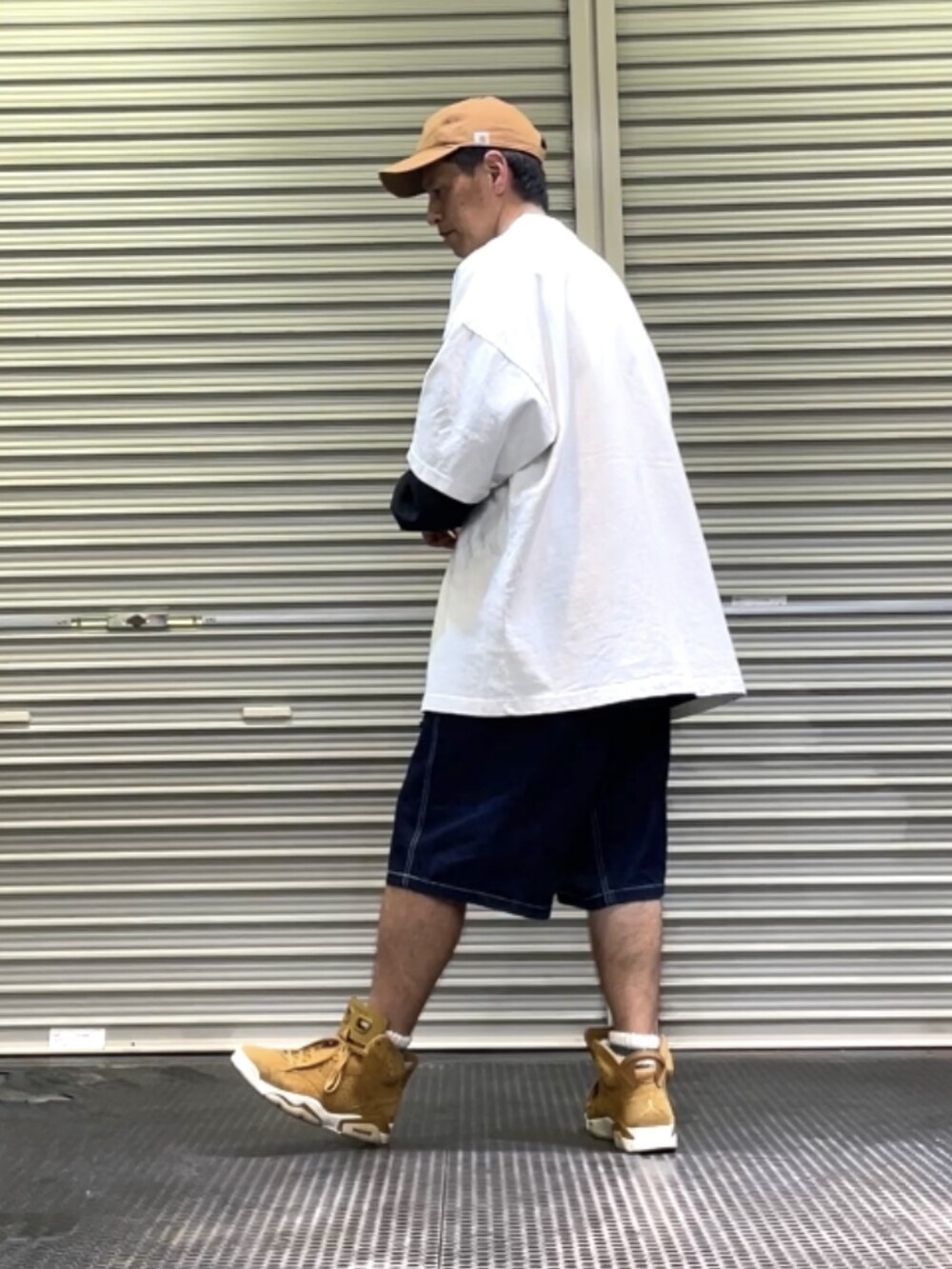 ブラウン系のスニーカー、ブルー系のデニムパンツ、ホワイト系のTシャツ/カットソーを着用したメンズの春コーディネートの2枚目の写真
