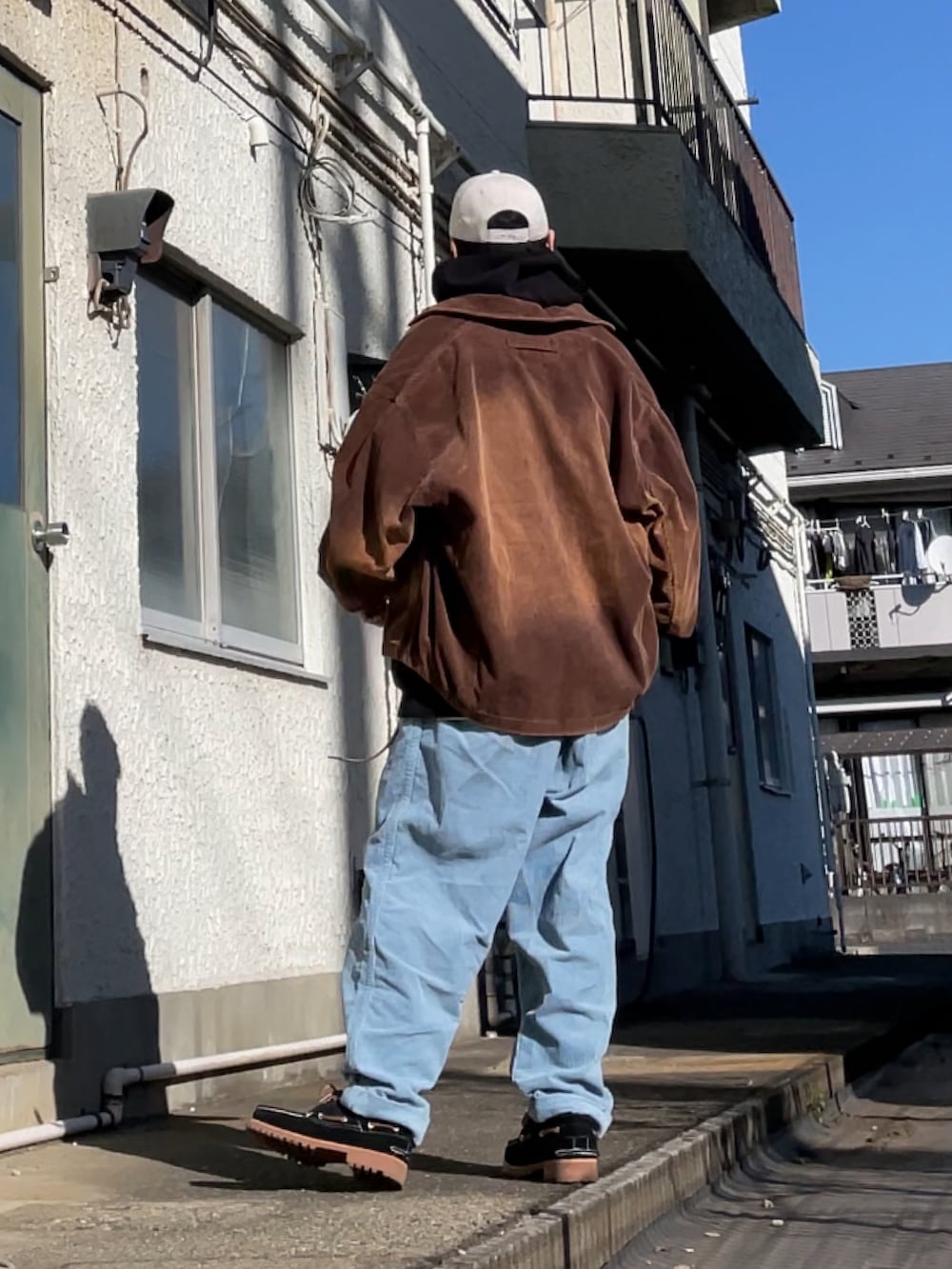 ブラック系のモカシン/デッキシューズ、ブルー系のその他パンツ、ブラック系のパーカーを着用したメンズの冬コーディネートの2枚目の写真