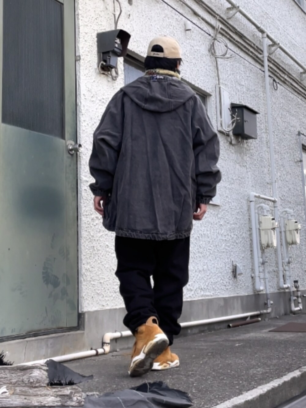 ブラウン系のスニーカー、ブラック系のスウェットパンツ、ホワイト系のスウェットを着用したメンズの冬コーディネートの2枚目の写真