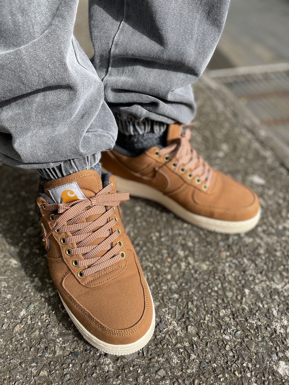 ブラウン系のスニーカー、グレー系のスウェットパンツ、ブラック系のTシャツ/カットソーを着用したメンズの春コーディネートの3枚目の写真