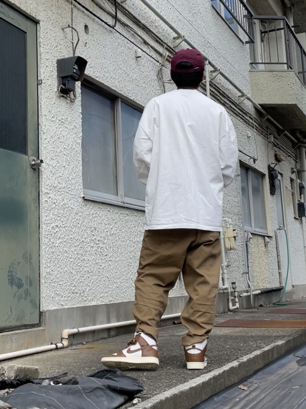 ブラウン系のスニーカー、ベージュ系のデニムパンツ、ホワイト系のTシャツ/カットソーを着用したメンズの秋コーディネートの2枚目の写真