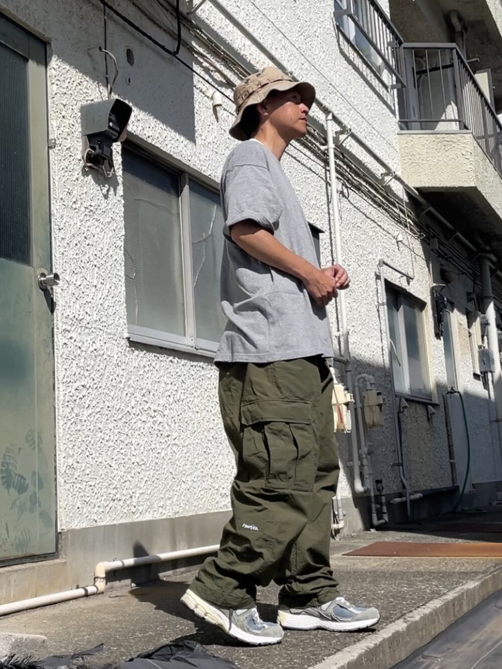 グレー系のスニーカー、グリーン系のカーゴパンツ、グレー系のTシャツ/カットソーを着用したメンズの秋コーディネートの2枚目の写真