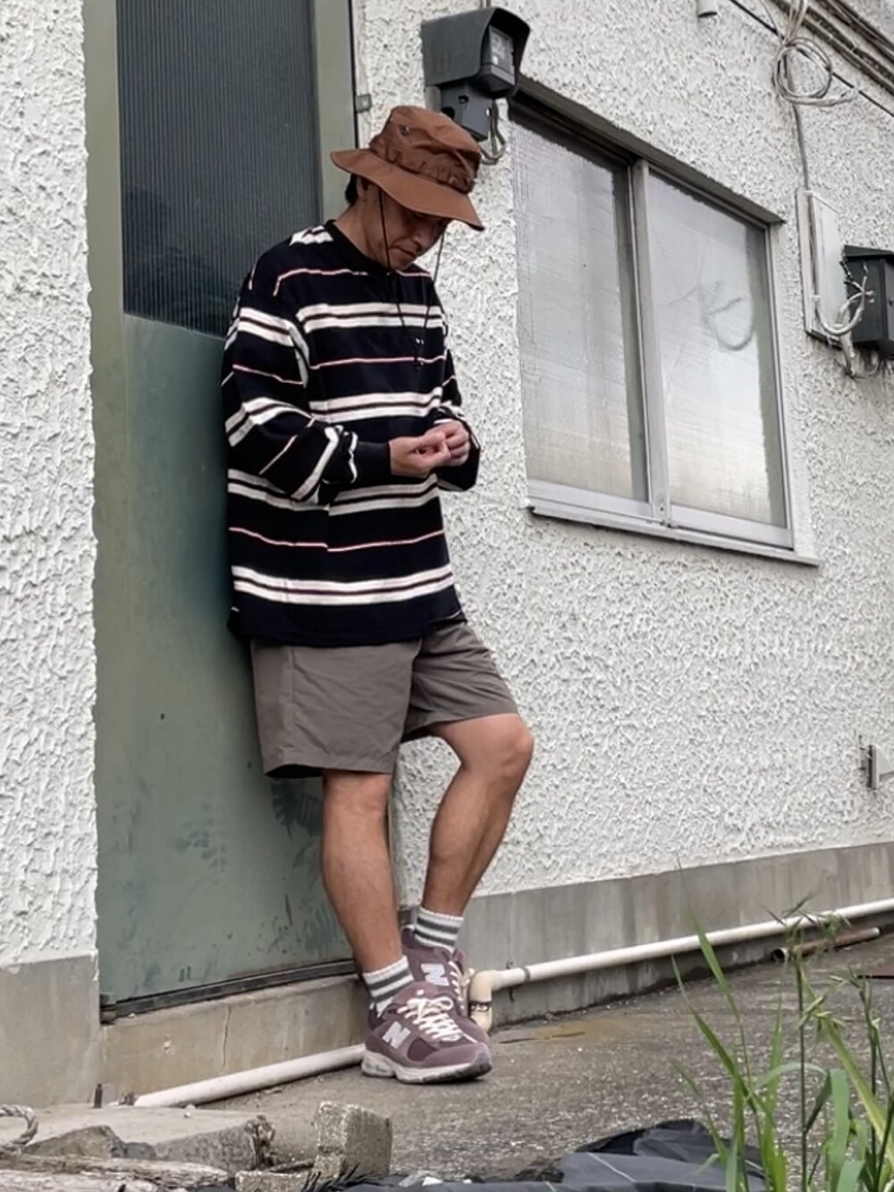 ブラウン系のスニーカー、ブラウン系のその他パンツ、ブラック系のTシャツ/カットソーを着用したメンズの春コーディネートの2枚目の写真