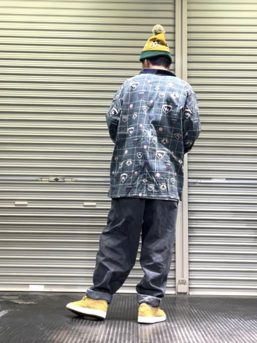 ベージュ系のスニーカー、ブラック系のデニムパンツ、グリーン系のポロシャツを着用したメンズの秋コーディネートの2枚目の写真