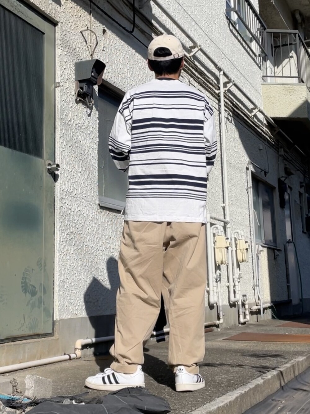 ホワイト系のスニーカー、ベージュ系のその他パンツ、ホワイト系のTシャツ/カットソーを着用したメンズの秋コーディネートの2枚目の写真