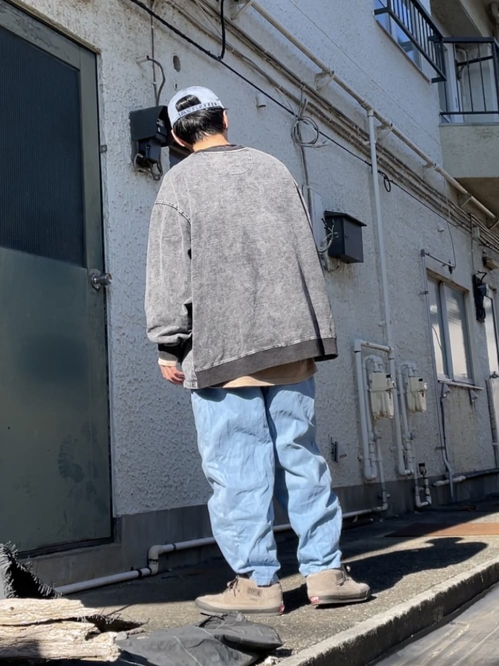 ベージュ系のスニーカー、ブルー系のデニムパンツ、ブラック系のスウェットを着用したメンズの冬コーディネートの2枚目の写真