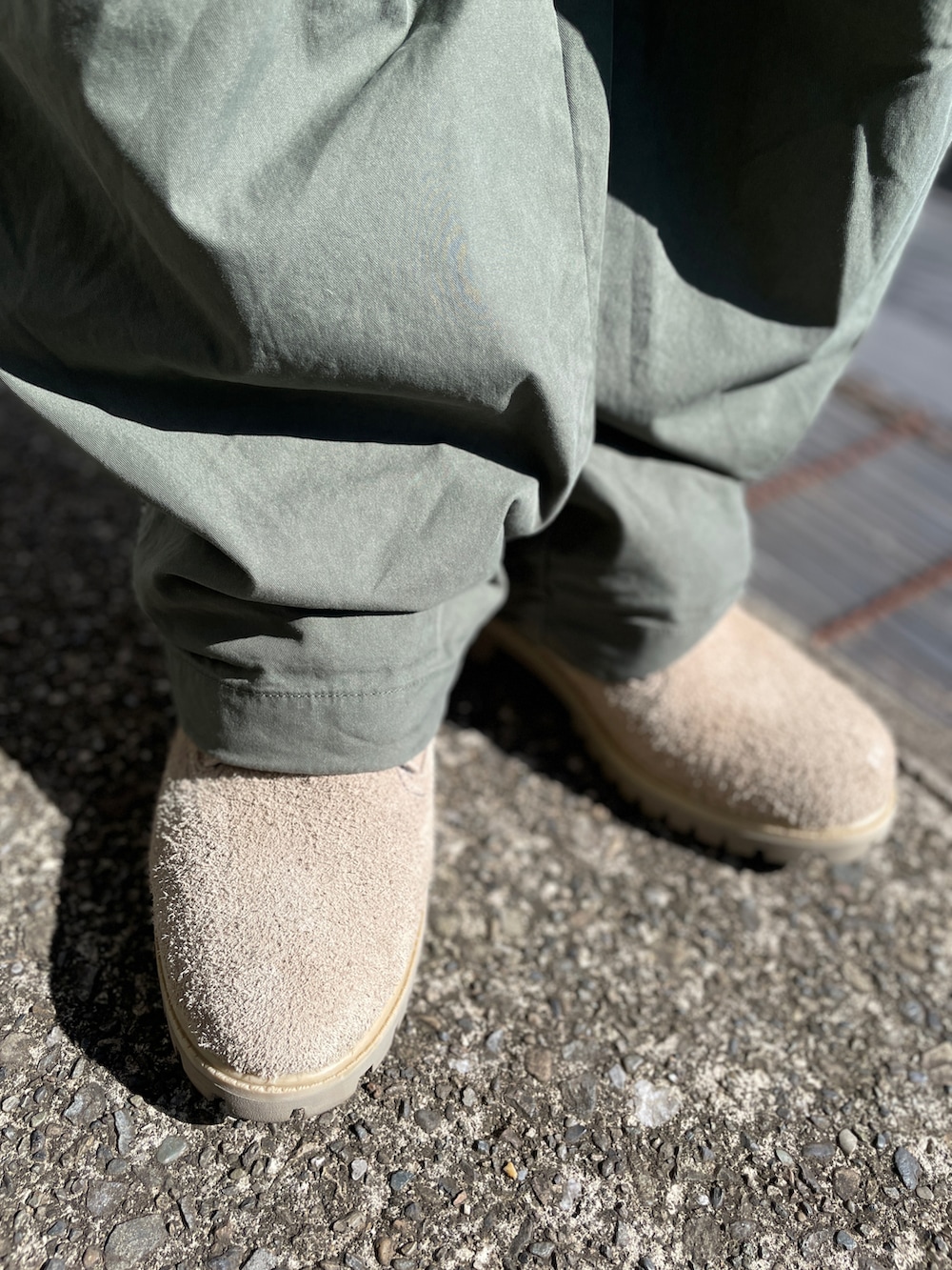 グレー系のTシャツ/カットソー、グリーン系のパンツ、ベージュ系のブーツを着用したメンズの秋コーディネートの3枚目の写真