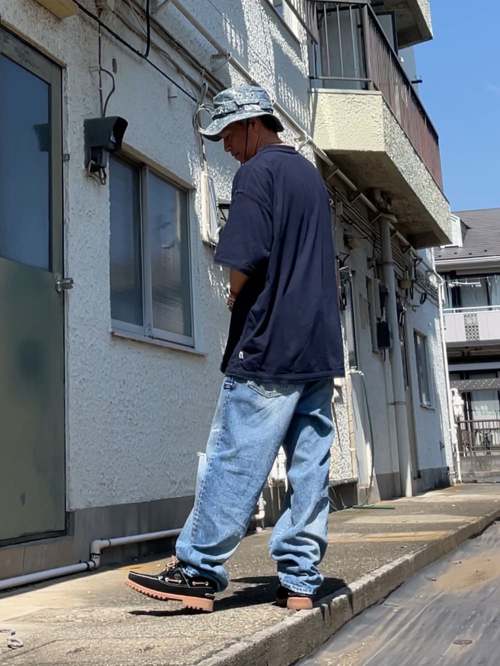 ブルー系のTシャツ/カットソー、ブルー系のデニムパンツ、ブラック系のモカシン/デッキシューズを着用したメンズの秋コーディネートの2枚目の写真