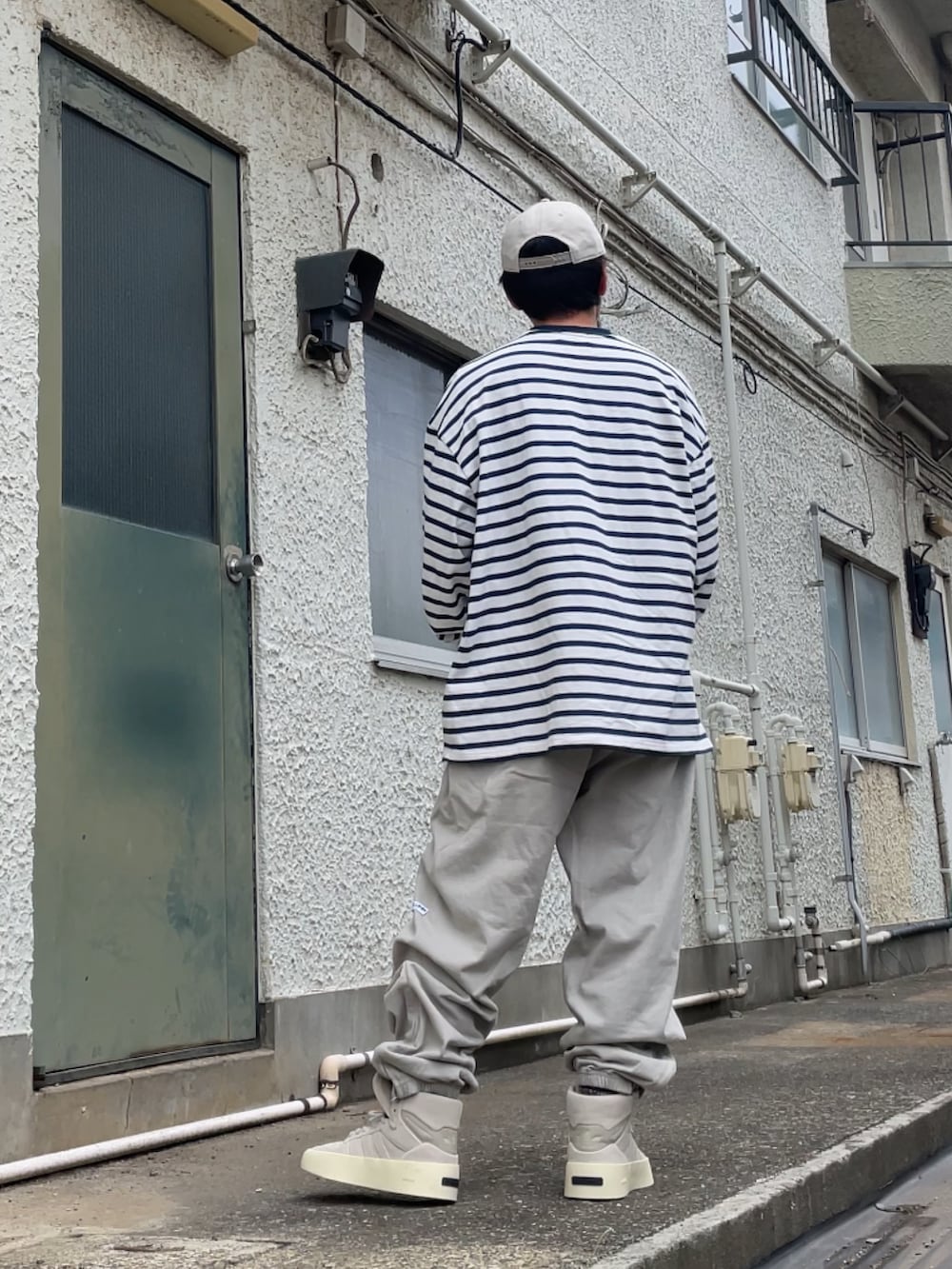 ベージュ系のスニーカー、グレー系のその他パンツ、ブルー系のTシャツ/カットソーを着用したメンズの春コーディネートの2枚目の写真