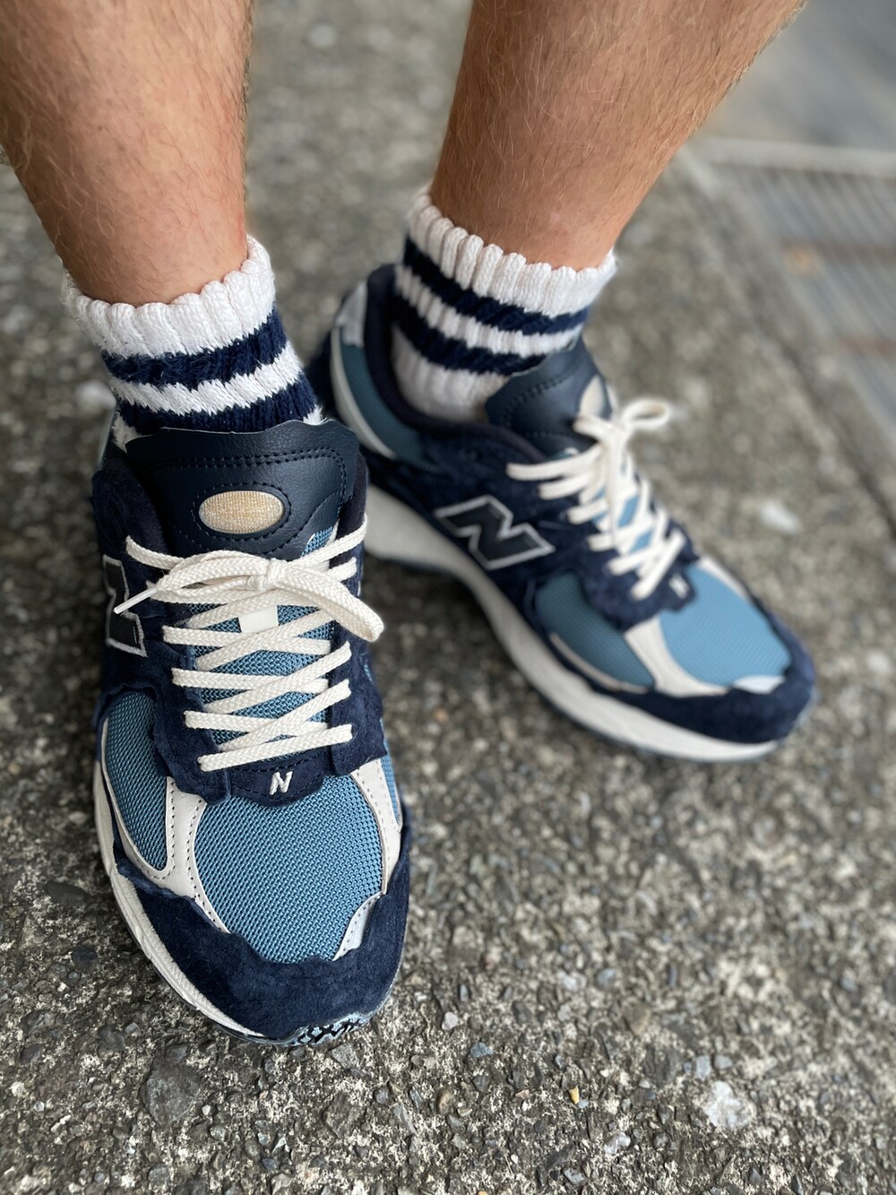 ブルー系のスニーカー、ブラック系のカーゴパンツ、ホワイト系のTシャツ/カットソーを着用したメンズの秋コーディネートの2枚目の写真