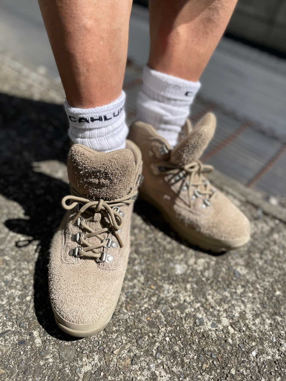 ブルー系のTシャツ/カットソー、ベージュ系のチノパンツ、ベージュ系のブーツを着用したメンズの秋コーディネートの3枚目の写真