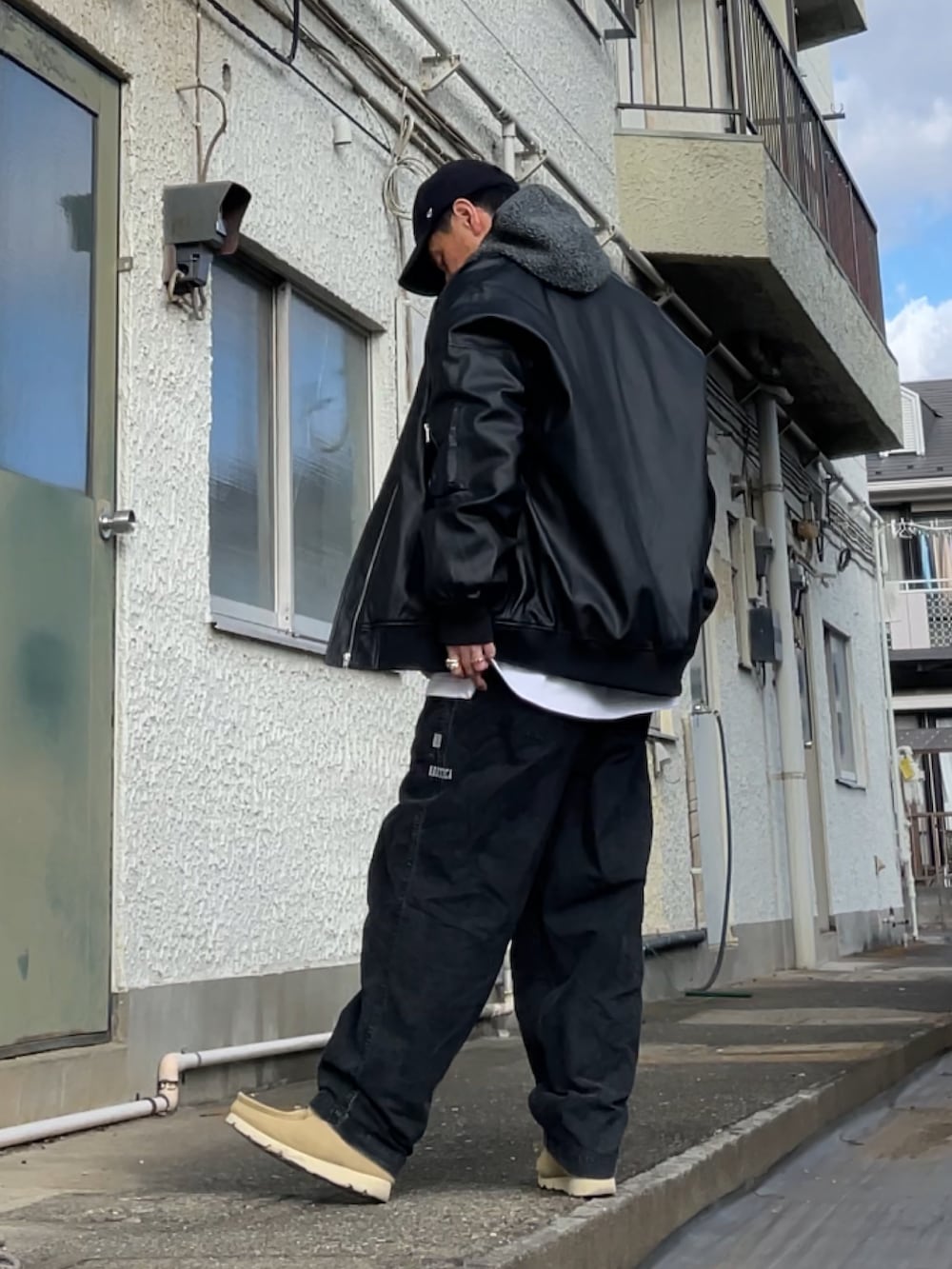 ブラック系のMA-1、ベージュ系のモカシン/デッキシューズ、グレー系のその他パンツを着用したメンズの冬コーディネートの2枚目の写真