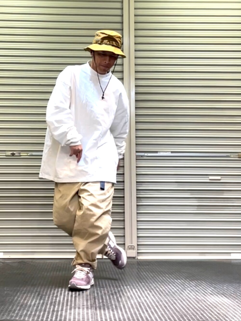 ブラウン系のスニーカー、ベージュ系のその他パンツ、ホワイト系のTシャツ/カットソーを着用したメンズの春コーディネートの2枚目の写真