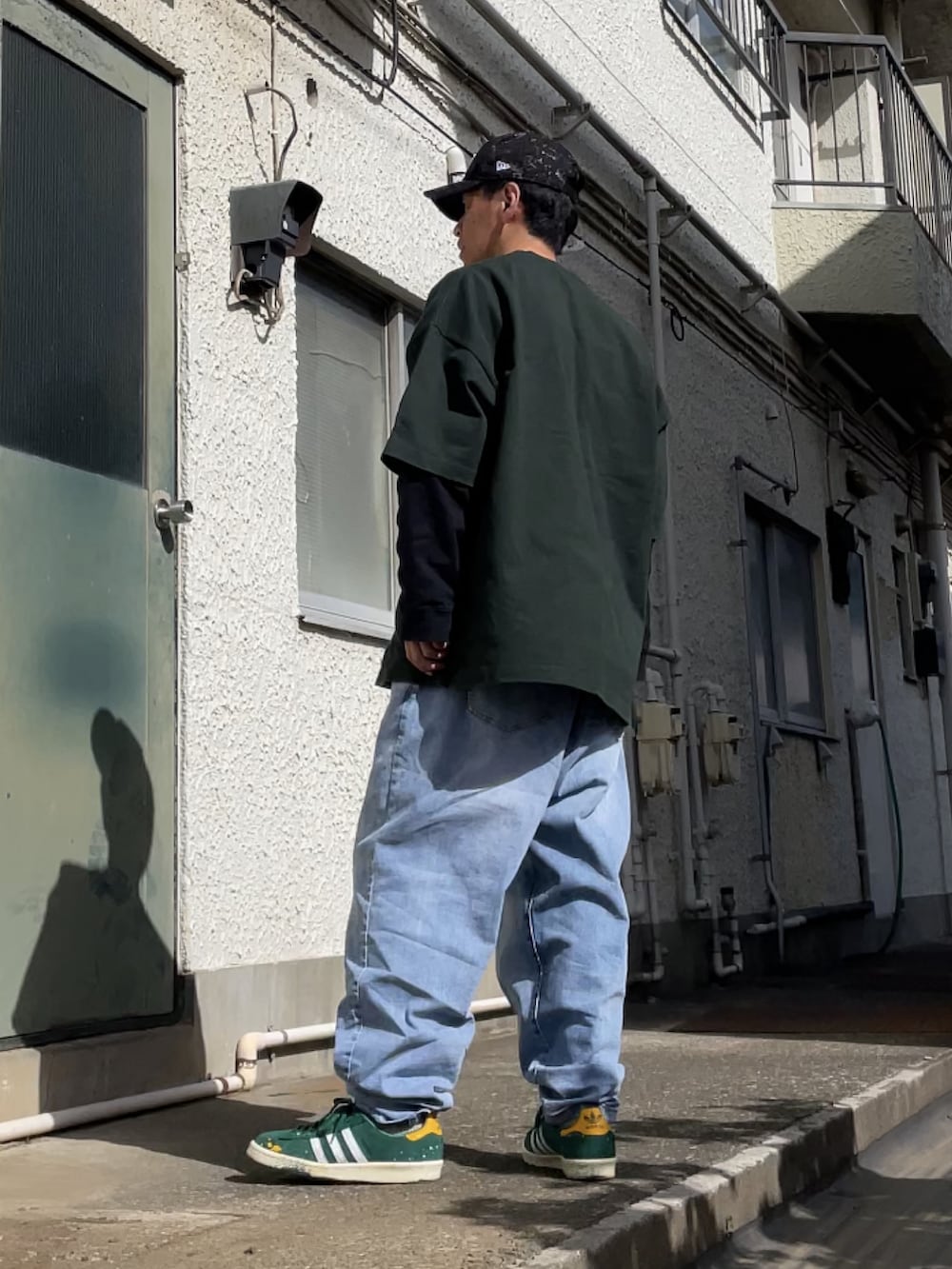 グリーン系のスニーカー、ブルー系のデニムパンツ、グリーン系のTシャツ/カットソーを着用したメンズの春コーディネートの2枚目の写真