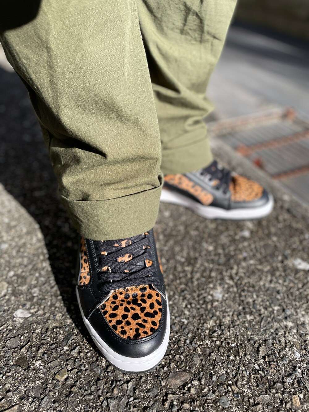 ブラック系のスニーカー、グリーン系のカーゴパンツ、ブラック系のベストを着用したメンズの冬コーディネートの3枚目の写真