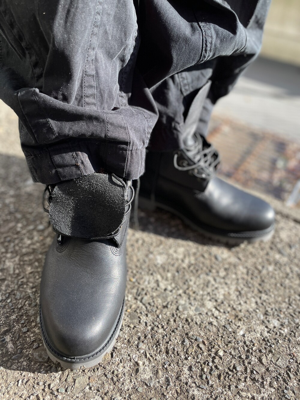 レッド系のニット/セーター、ブラック系のブーツ、ブラック系のパンツを着用したメンズの冬コーディネートの3枚目の写真