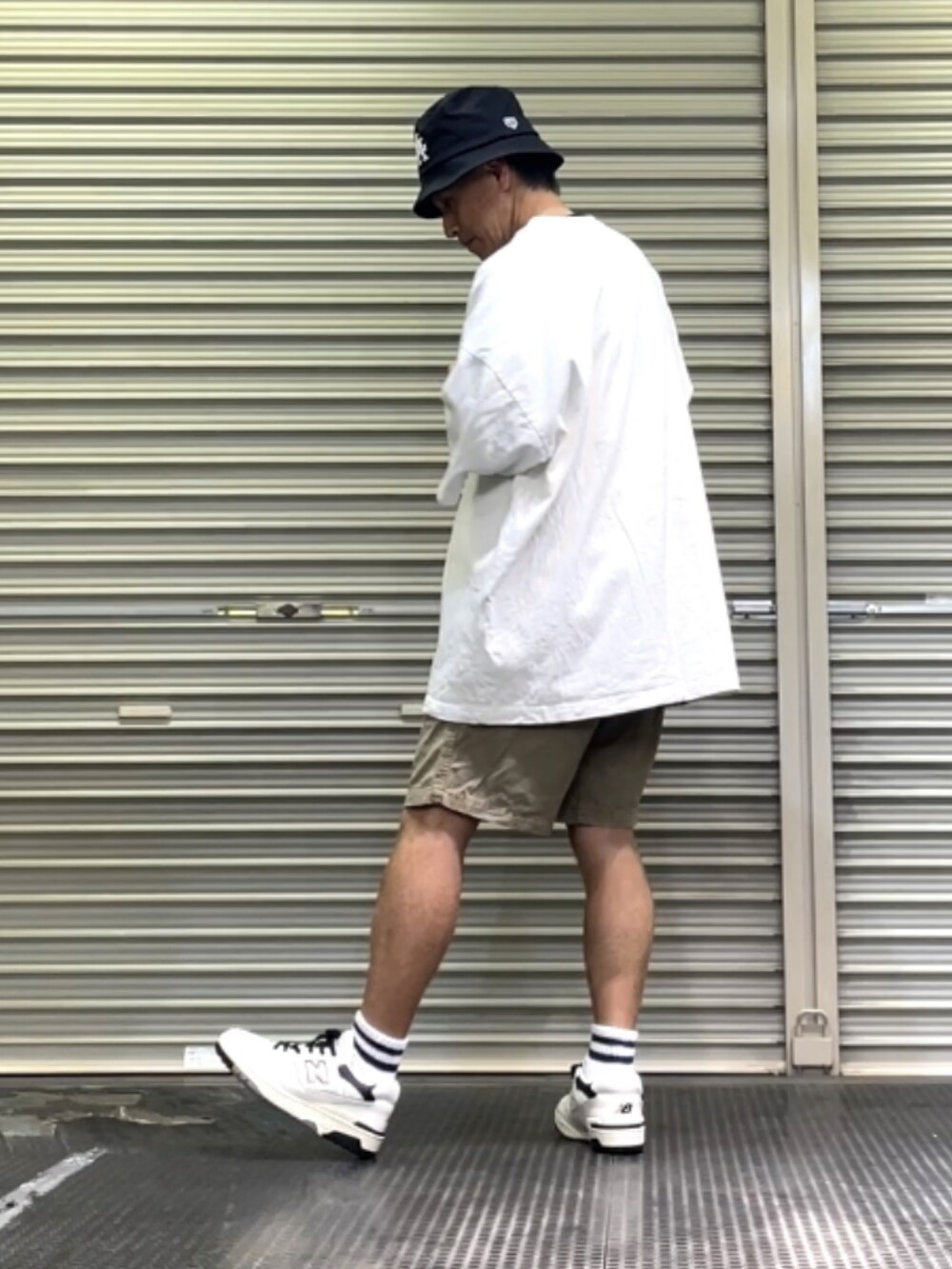 ホワイト系のスニーカー、グリーン系のパンツ、ホワイト系のTシャツ/カットソーを着用したメンズの秋コーディネートの2枚目の写真