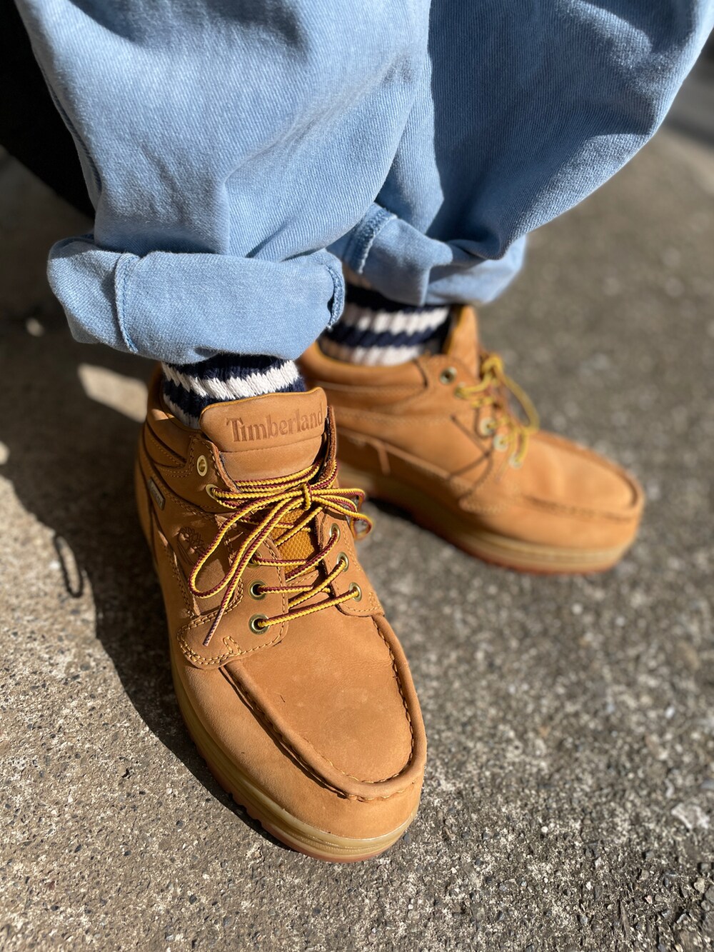 グリーン系のブーツ、ブルー系のデニムパンツ、ブルー系のTシャツ/カットソーを着用したメンズの秋コーディネートの3枚目の写真