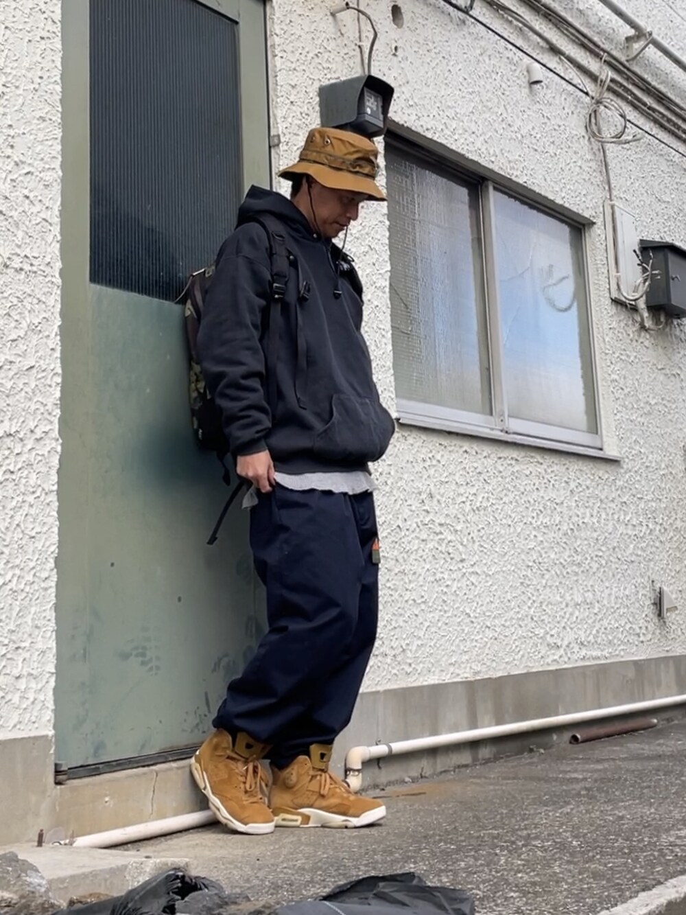 ブラウン系のスニーカー、ブルー系のチノパンツ、その他のバックパック/リュックを着用したメンズの秋コーディネートの3枚目の写真