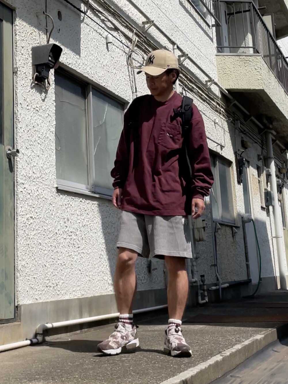 ブラウン系のスニーカー、グレー系のその他パンツ、レッド系のスウェットを着用したメンズの春コーディネートの3枚目の写真